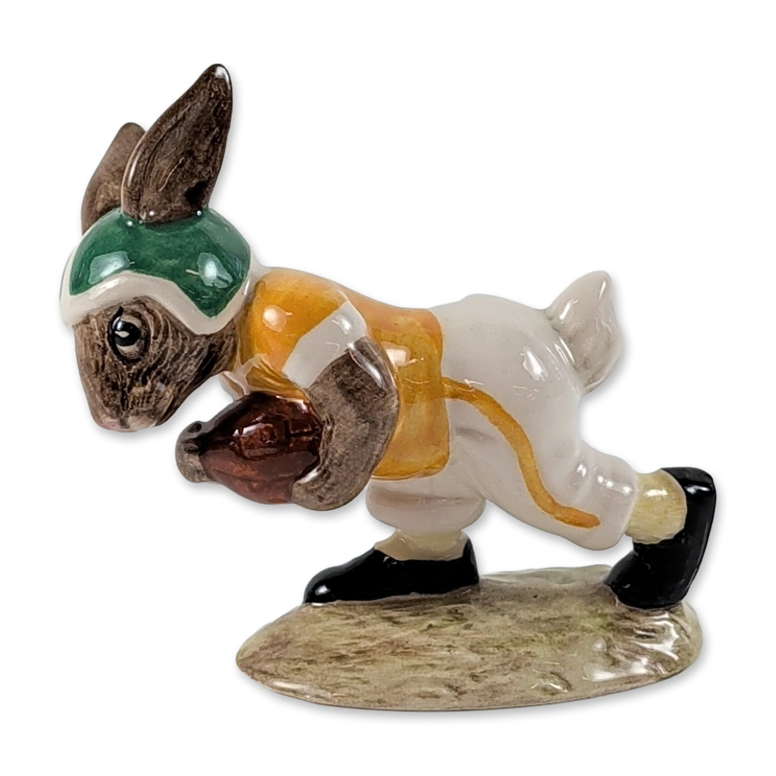 Royal Doulton Touchdown Bunnykins Figurine DB99: Royal Doulton polychrome glazed ceramic figurine from the Bunnykins series titled Touchdown Bunnykins. The figure depicts a rabbit as an American football player in a diving pose, dressed in a green h