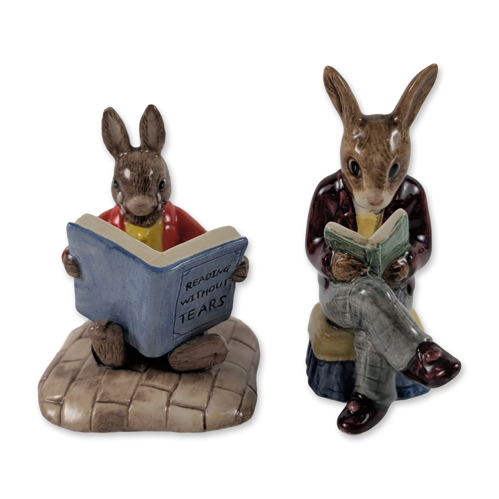 2pc Royal Doulton Bunnykins Ceramic Figurines: Royal Doulton. Two Bunnykins figurines in glazed ceramic, featuring rabbits engaged in reading. Includes Grandpa's Story (DB 14) depicting an elderly rabbit in a maroon jacket and grey trousers readin