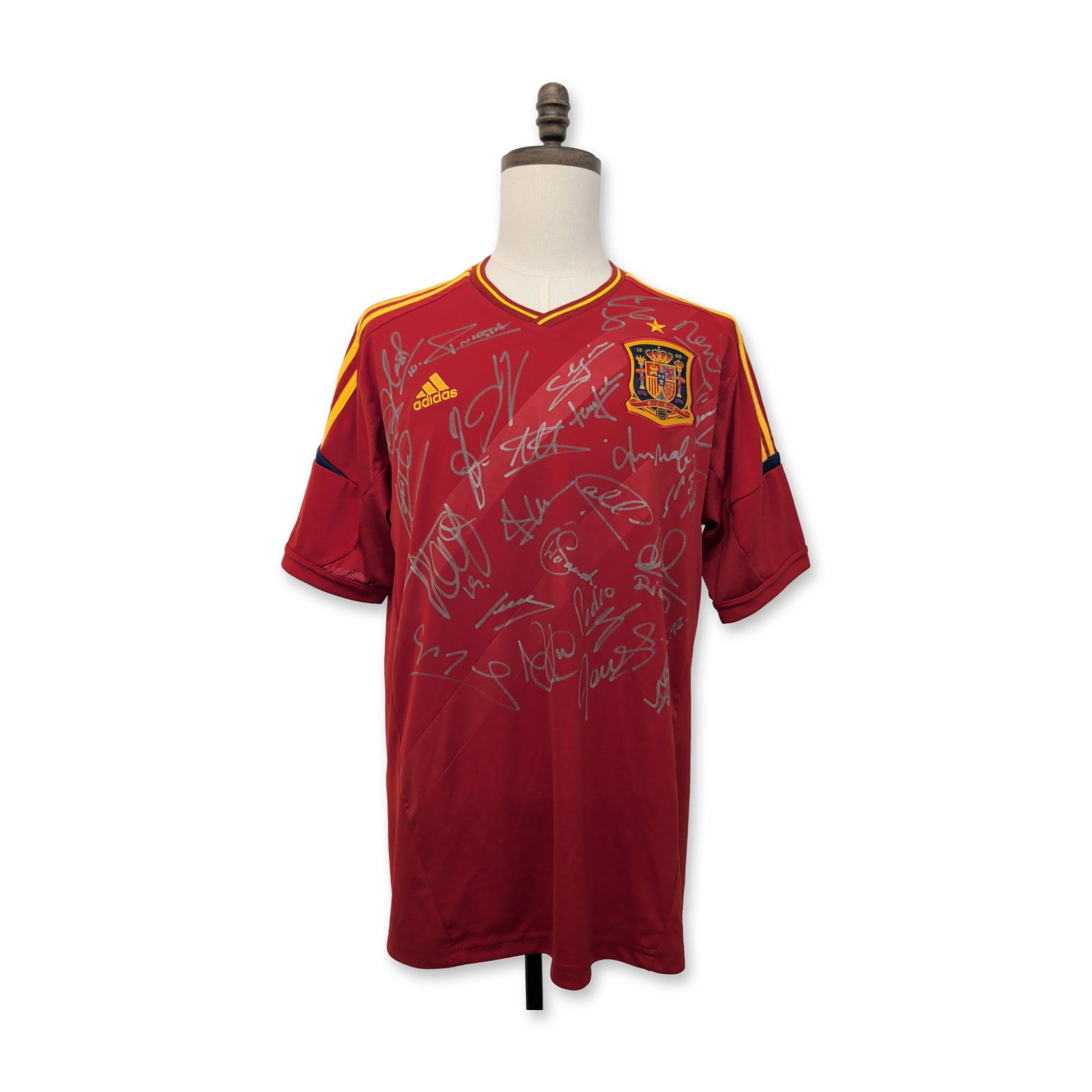 Spain 2012 Euro Multi-Autographed Soccer Jersey: Adidas Spain national team home jersey, attributed to the 2012 Euro Final squad. Red short-sleeve Climacool kit featuring yellow shoulder stripes and blue trim at the collar and cuffs. The front displ