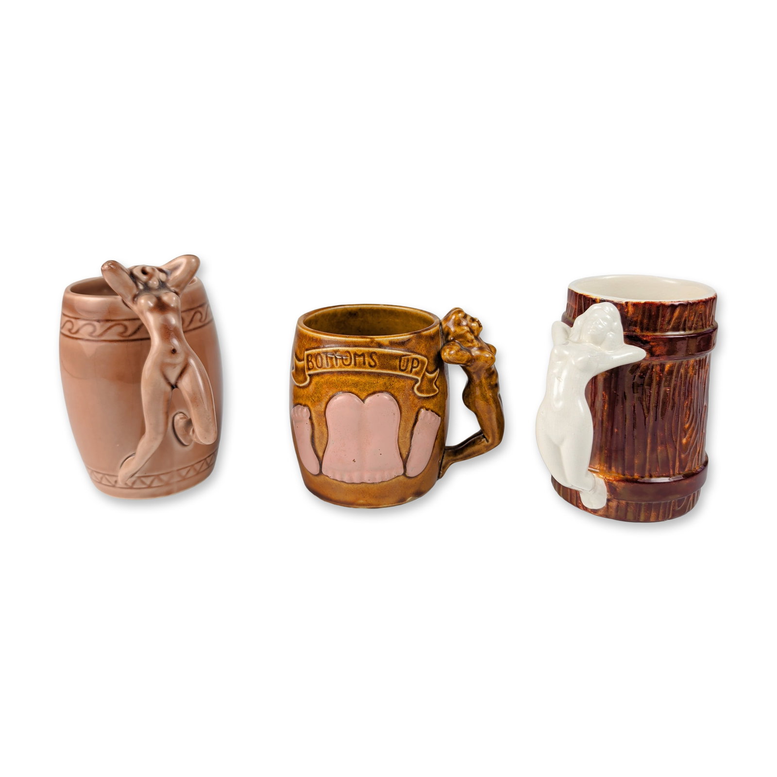3pc Erotic Nude Handle Ceramic Mugs: Ceramic novelty barware mugs featuring figural nude handles. One example is designed as a textured woodgrain barrel with a white-glazed reclining female figure handle and a white interior. The second