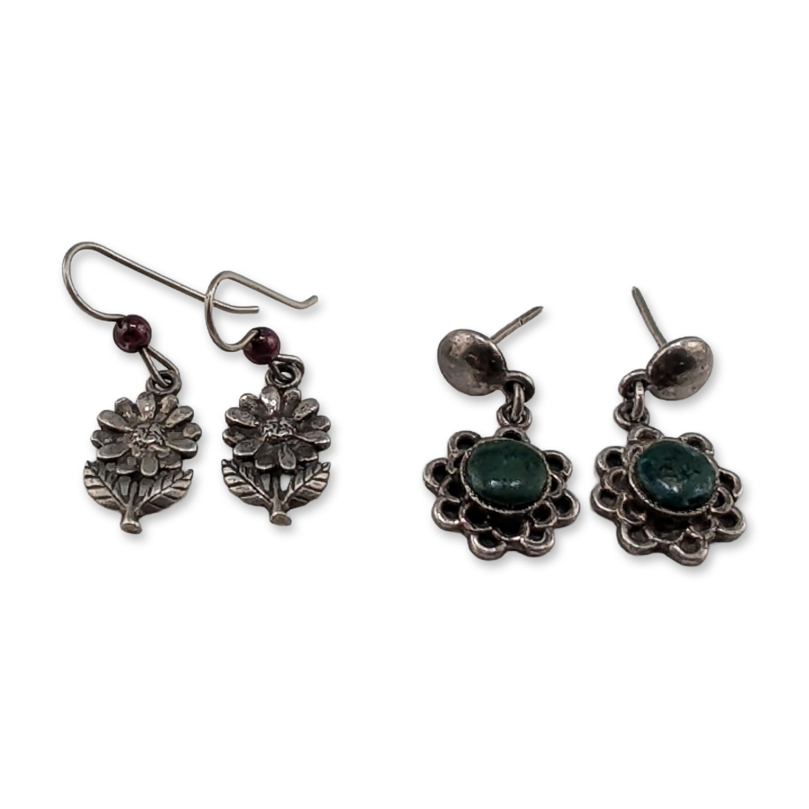 Two Pairs of Vintage Sterling Silver and 950 Silver Dangle Earrings: Group of two pairs of vintage silver drop earrings. The first pair features oval green cabochon stones set within scalloped floral borders and finished with post-style backings. The reverse of each