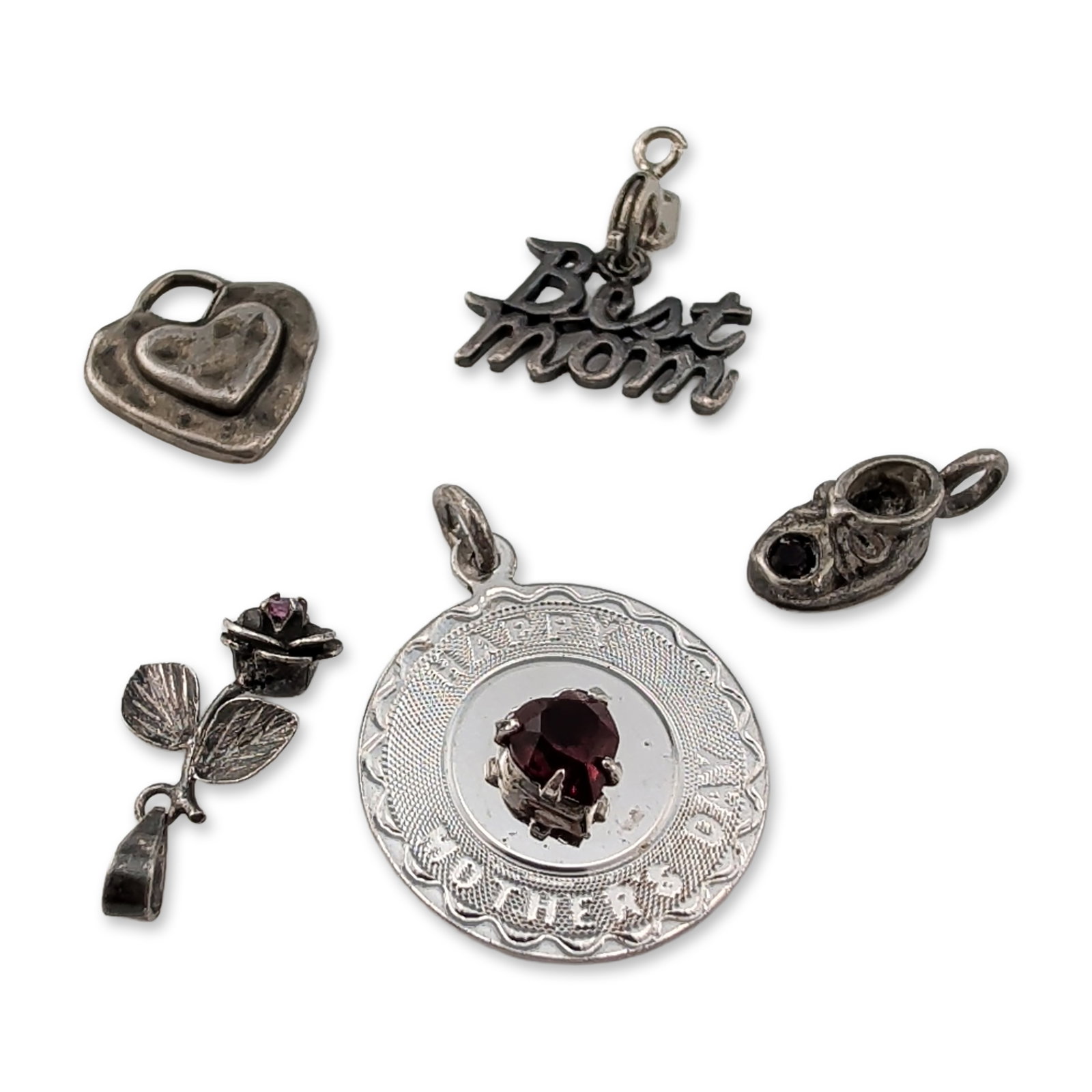 Collection of Sterling Silver Pendants: Collection of five sterling silver pendants and charms with sentimental and figural themes. The lot includes a circular medallion inscribed Happy Mother's Day with a central heart-shaped red faceted