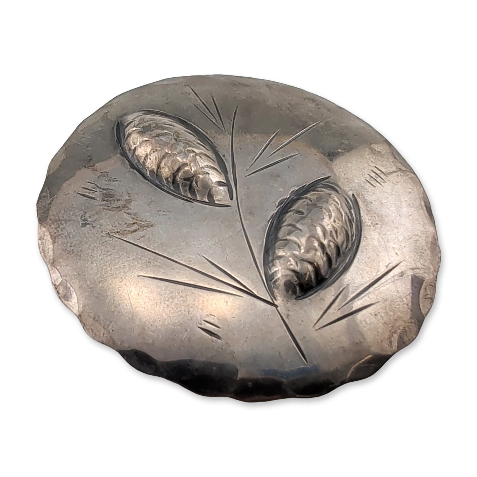 Stuart Nye Sterling Silver Pinecone Brooch: Stuart Nye sterling silver oval brooch featuring hand-chased and repousse pinecone and needle motifs set against a hammered ground with a scalloped border. The reverse is marked with the Stuart Nye