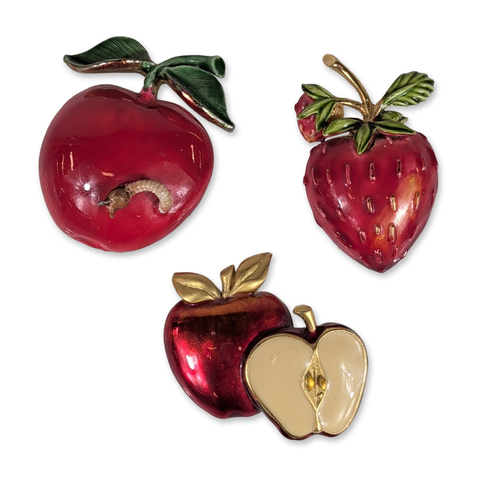 Trio of Vintage Enameled Fruit Brooches: Original by Robert and style vintage figural fruit brooches in gold-tone metal and enamel. The collection features a whole red apple with an emerging gold-tone worm and green enameled leaves, a vertic