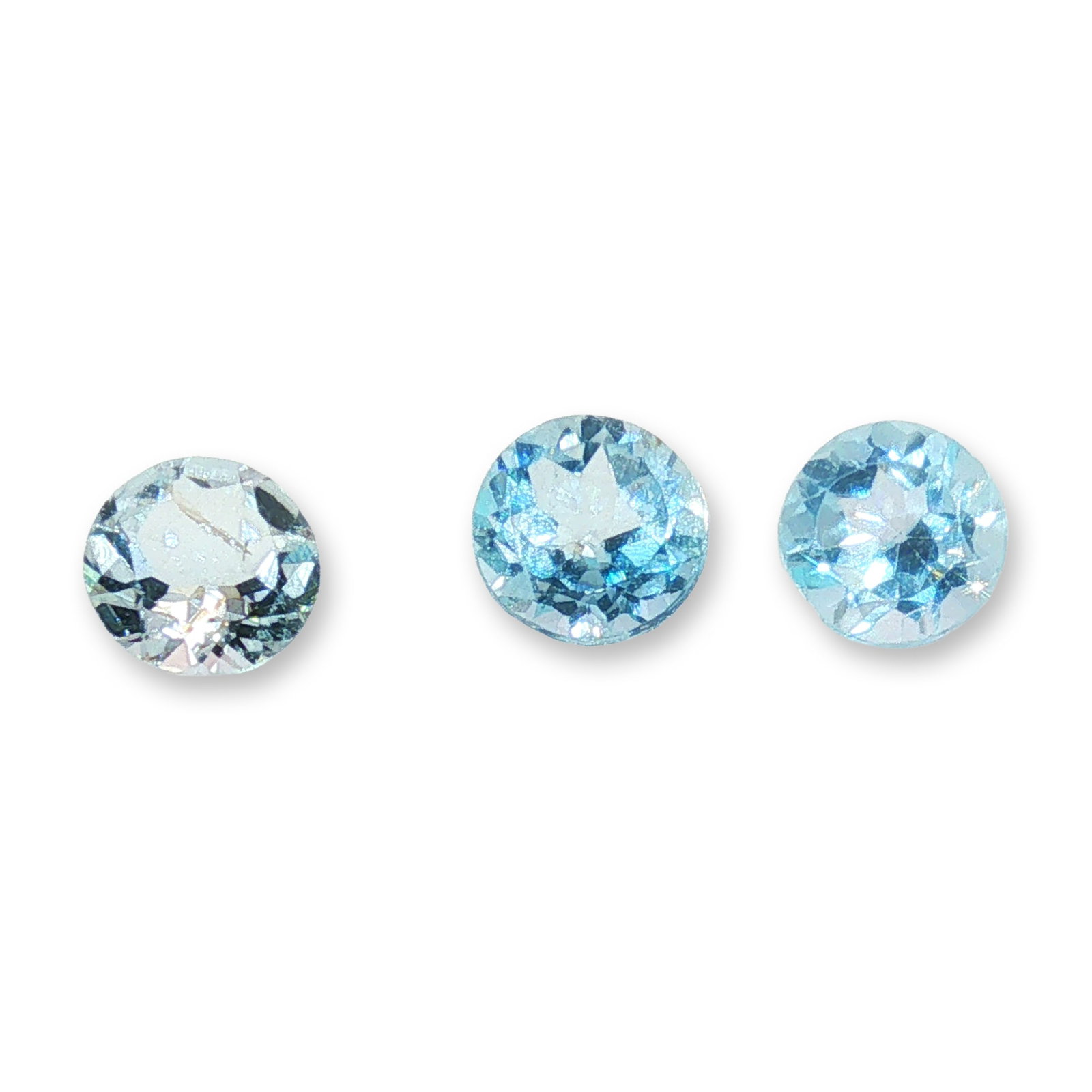 Trio of Round Cut Loose Aquamarine Gemstones: Trio of loose gemstones appearing to be natural aquamarine, featuring a classic round brilliant cut. The stones exhibit a delicate light blue hue suitable for custom jewelry designs. Visual