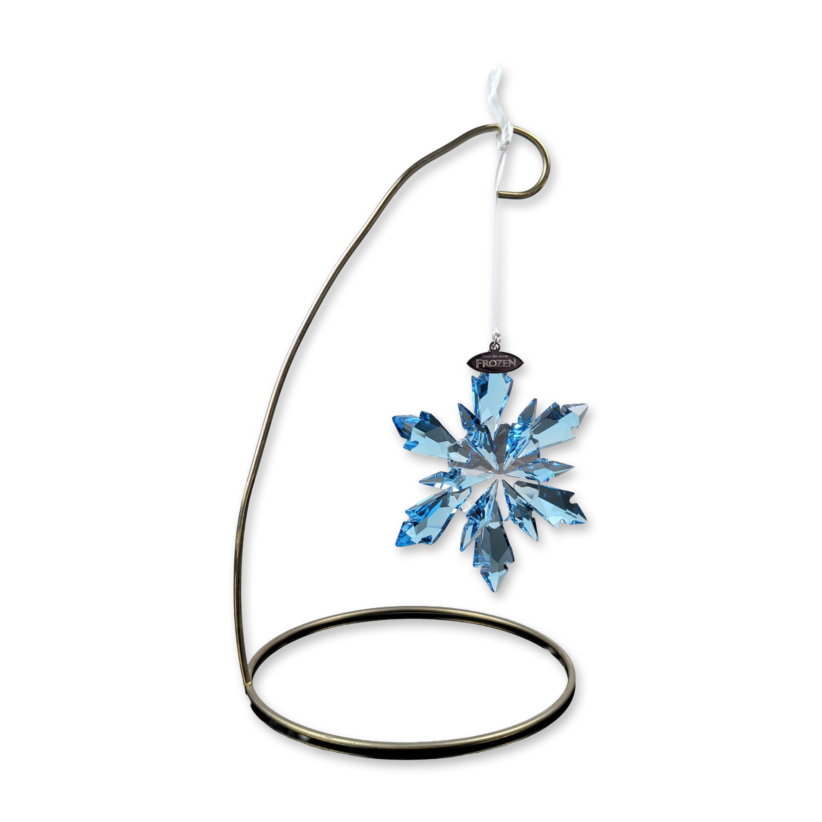 Swarovski Disney Frozen Crystal Snowflake Ornament: Swarovski Disney Frozen snowflake ornament in faceted blue crystal. The six-pointed star features tiered, sharp-angled facets designed for light refraction, suspended from a white ribbon with a silver
