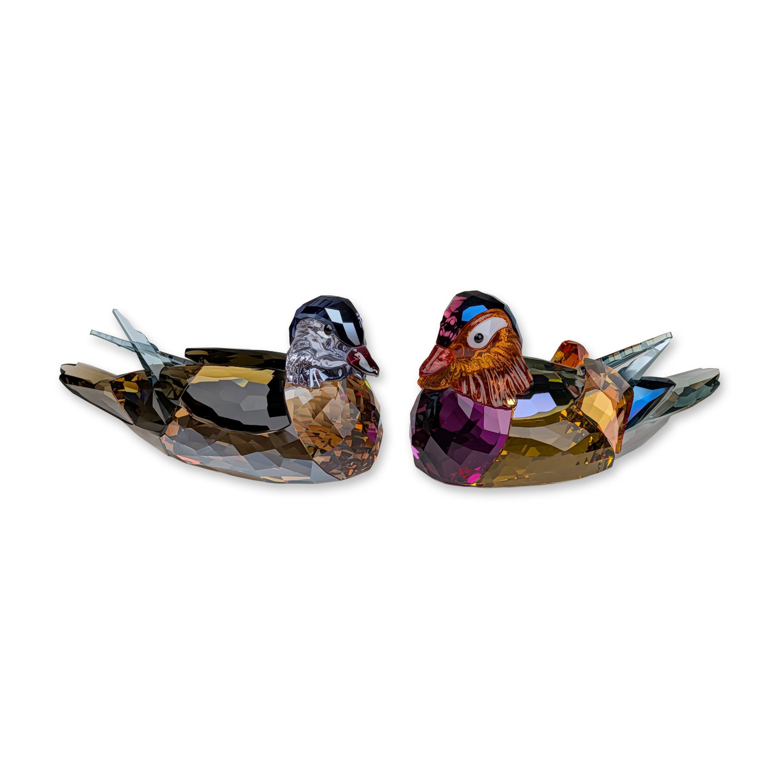 Swarovski Crystal Mandarin Duck Figurines: Swarovski pair of multi-colored faceted crystal mandarin duck figurines in amber, violet, and teal hues, featuring etched swan logo and copyright mark to the undersides, accompanied by original brande