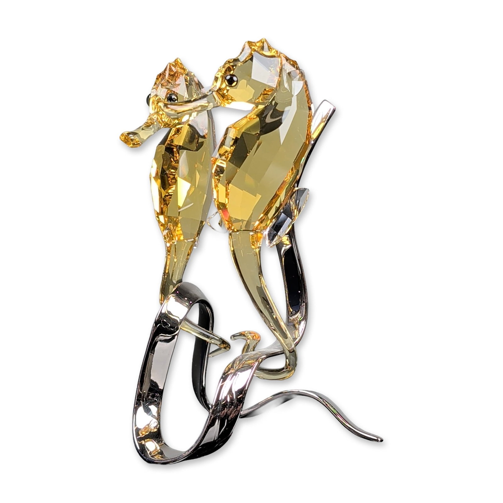 Swarovski Crystal Paradise Fish Figurine, Light Topaz Seahorses: Swarovski crystal seahorses figurine from the South Sea collection, featuring two faceted amber-toned crystal seahorses with black eyes. The figures are mounted on a flowing, polished rhodium-plated m