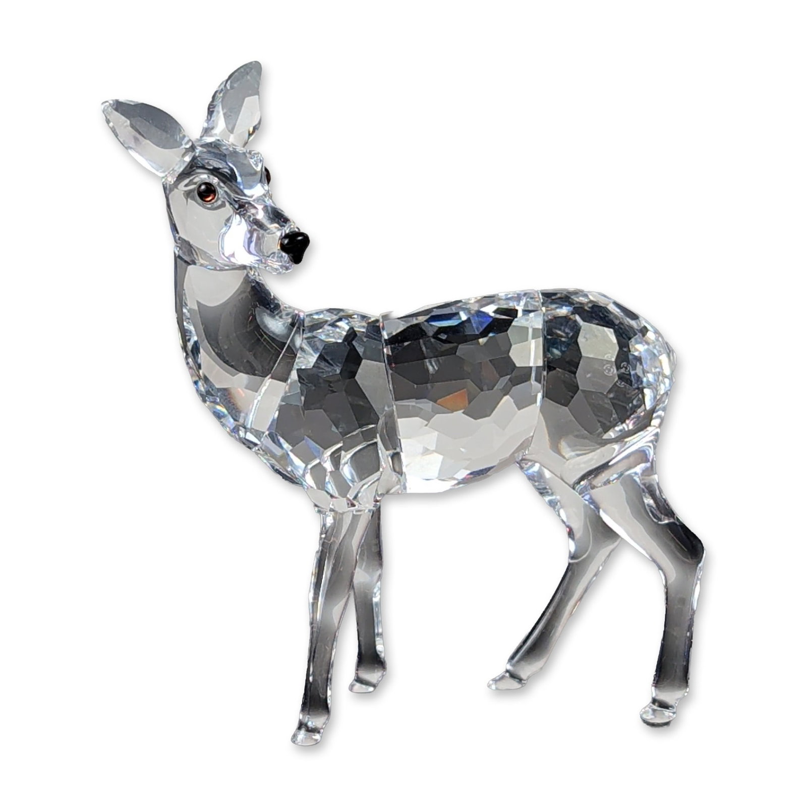 Swarovski Silver Crystal Standing Doe Figurine: Swarovski Silver Crystal standing doe figurine in clear faceted lead crystal with black crystal accents for the eyes and nose. The figure is designed with a faceted body and neck contrasted by