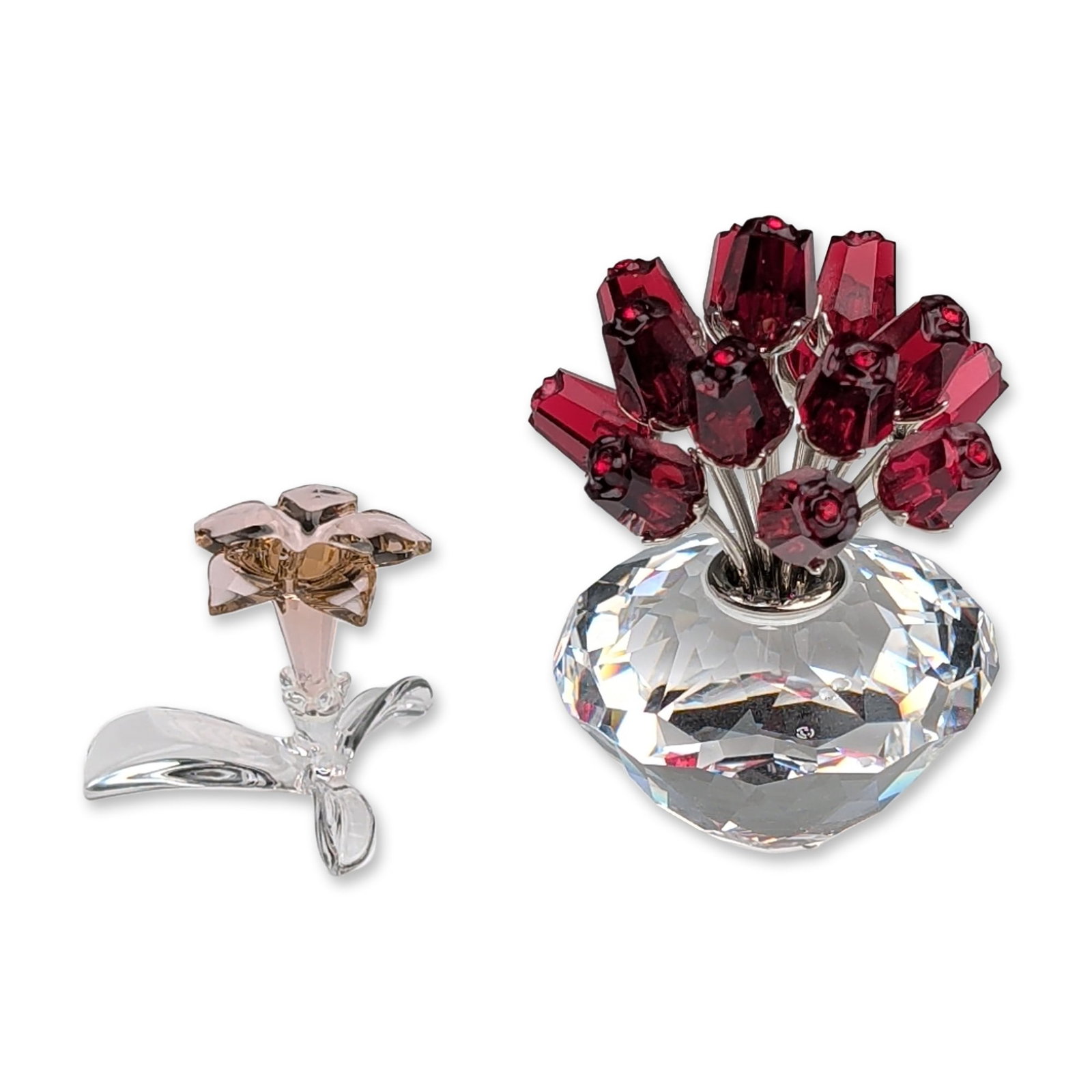 Two Swarovski Crystal Flower Figurines, Vase of Roses and Dessert Rose: This lot includes the 15th Anniversary Edition "Vase of Roses" featuring fifteen faceted red crystal rosebuds on silver-tone metal stems set into a clear faceted diamond-form base. Also included is a 