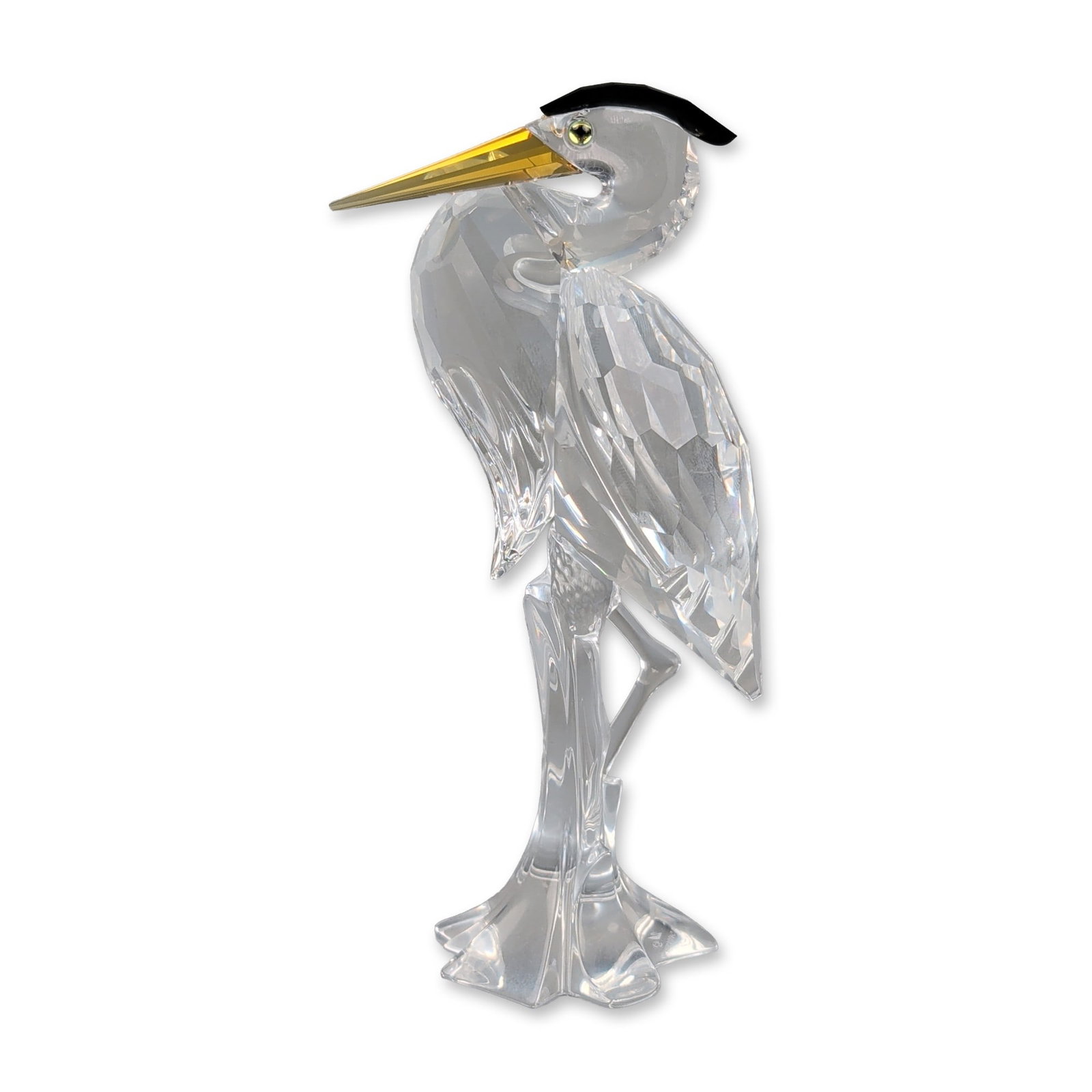 Swarovski Silver Crystal Heron Figurine: Swarovski Silver Crystal heron figurine in faceted and smooth lead crystal. The piece features a multi-faceted body and wings with a smooth neck and head. Accents include a black crystal crest, amber-