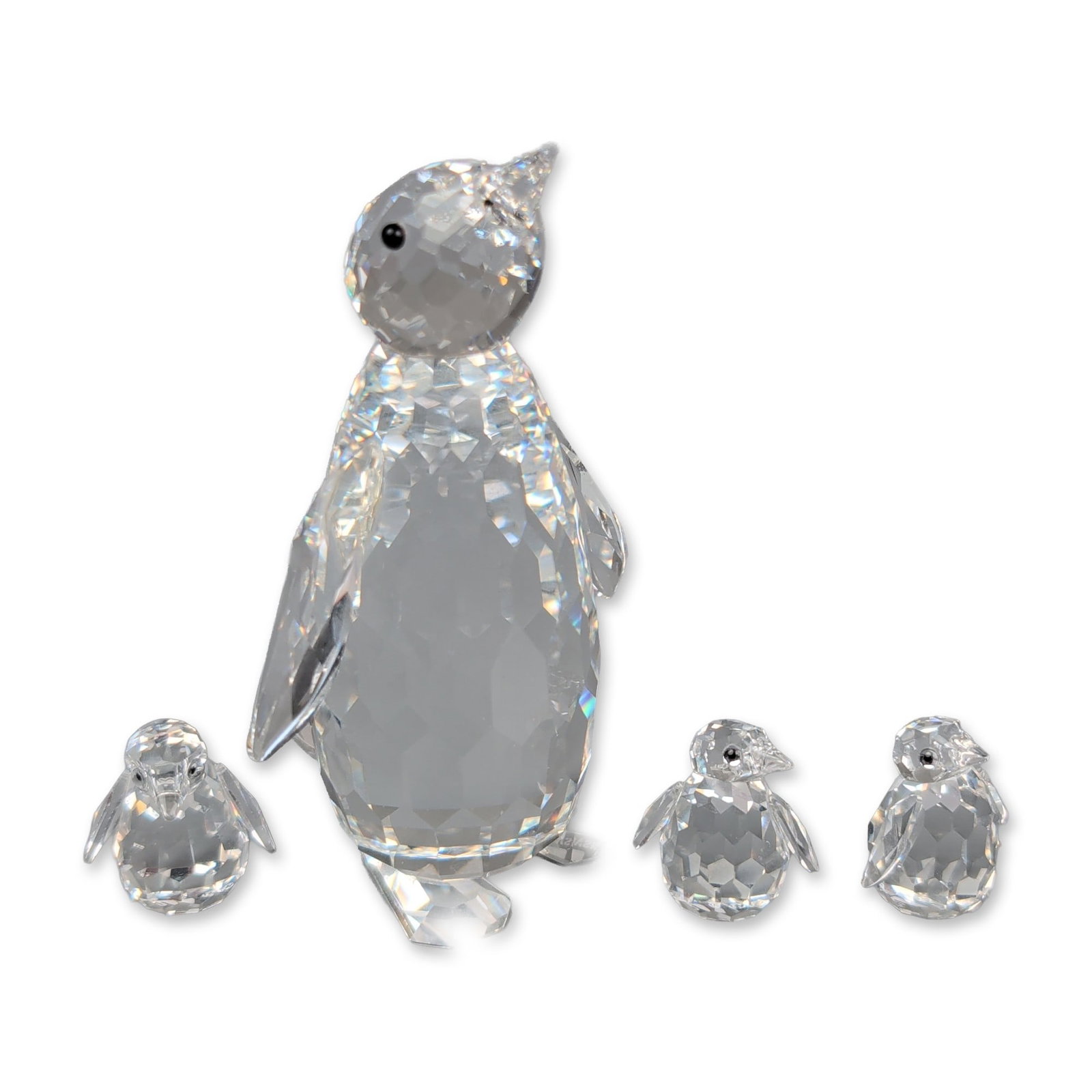 4pc Swarovski Silver Crystal Figurines, Large Penguin and Set of Baby Penguins: Four-pieces in faceted clear lead crystal with inset black bead eyes, including one adult and three chicks. The base of the larger figure features an acid-etched swan logo and the text (c)SWAROVSKI. I
