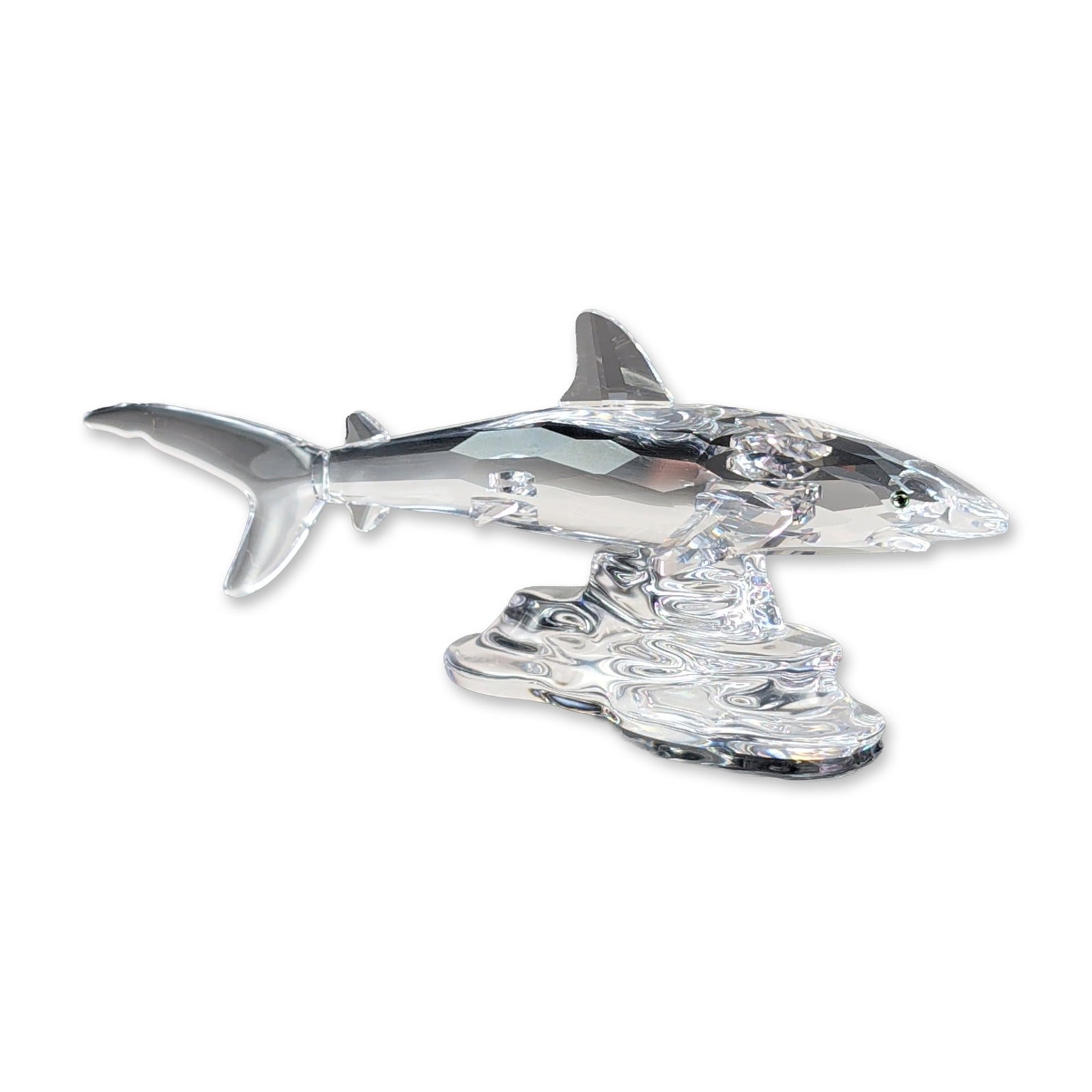 Swarovski Silver Crystal Faceted Shark Figurine: Swarovski, Austria. A faceted lead crystal figurine from the Silver Crystal series depicting a shark swimming on textured water looking base. The sharks are constructed from clear faceted crystal with
