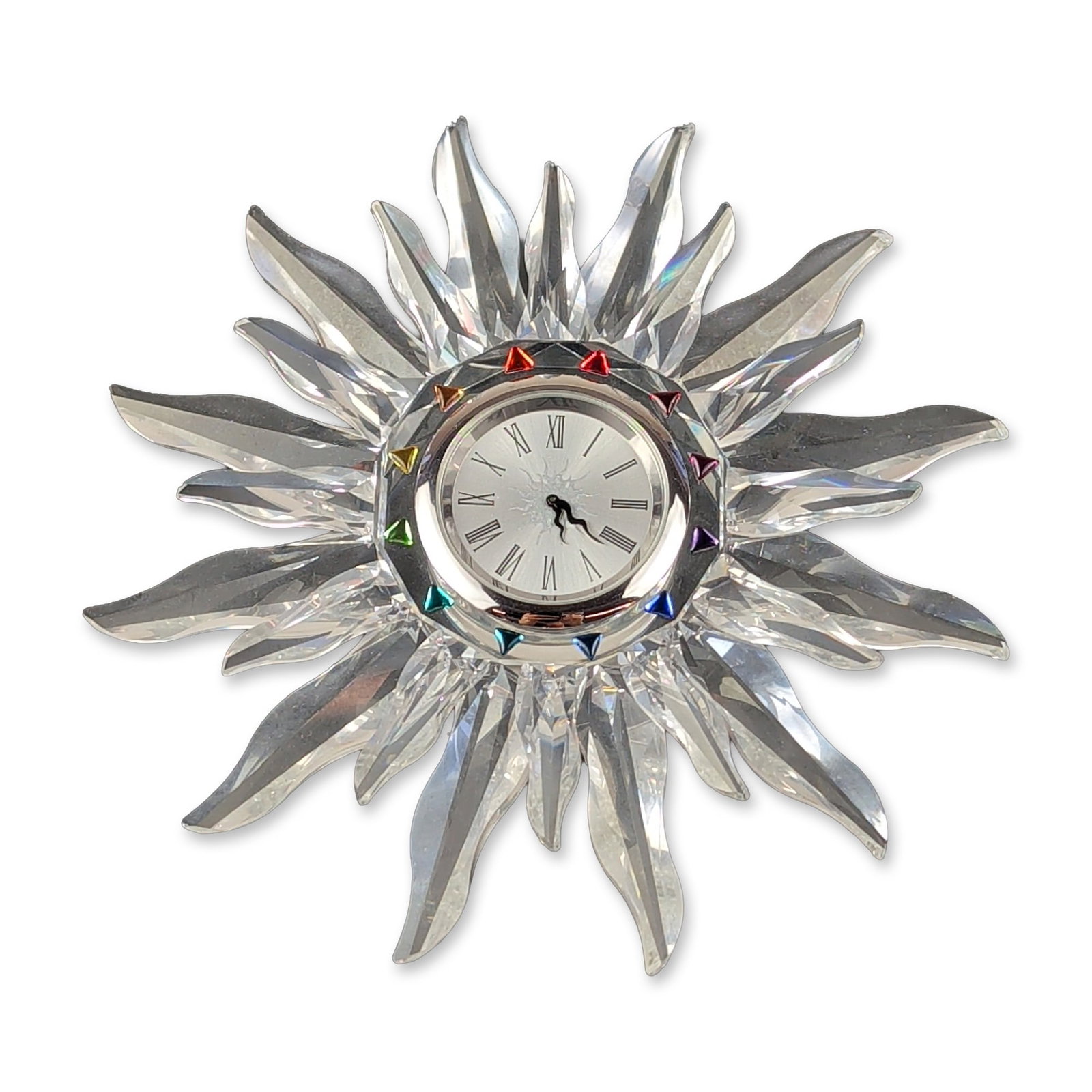 Swarovski Silver Crystal Solaris Table Clock: Swarovski faceted lead crystal desk clock in the Solaris pattern, designed as a multi-faceted sunburst. The central silver-toned metal bezel is inset with twelve triangular-cut crystals in a spectrum 