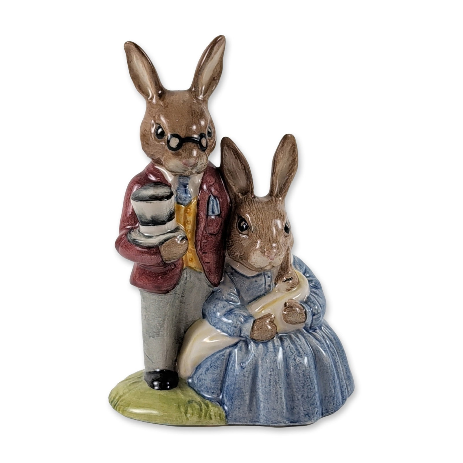 Royal Doulton Bunnykins Family Figurine DB68: Royal Doulton Bunnykins glazed porcelain figurine titled Father, Mother and Victoria. The piece depicts an anthropomorphic rabbit family group with the father rabbit wearing spectacles and a maroon ja