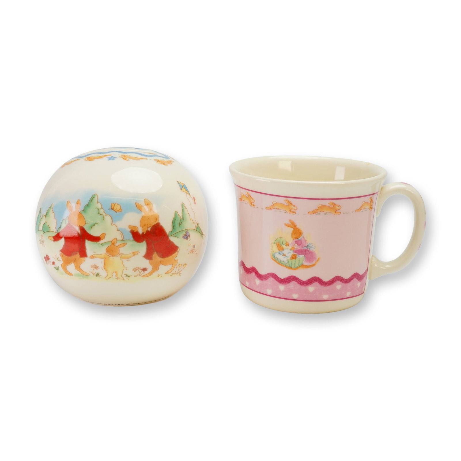 2pc Royal Doulton Bunnykins Bone China Money Ball and Mug: This 2pc Royal Doulton Bunnykins bone china set consists of a money ball and a mug. The money ball is from the Shining Stars series and is constructed as a spherical bank featuring a coin slot at the 