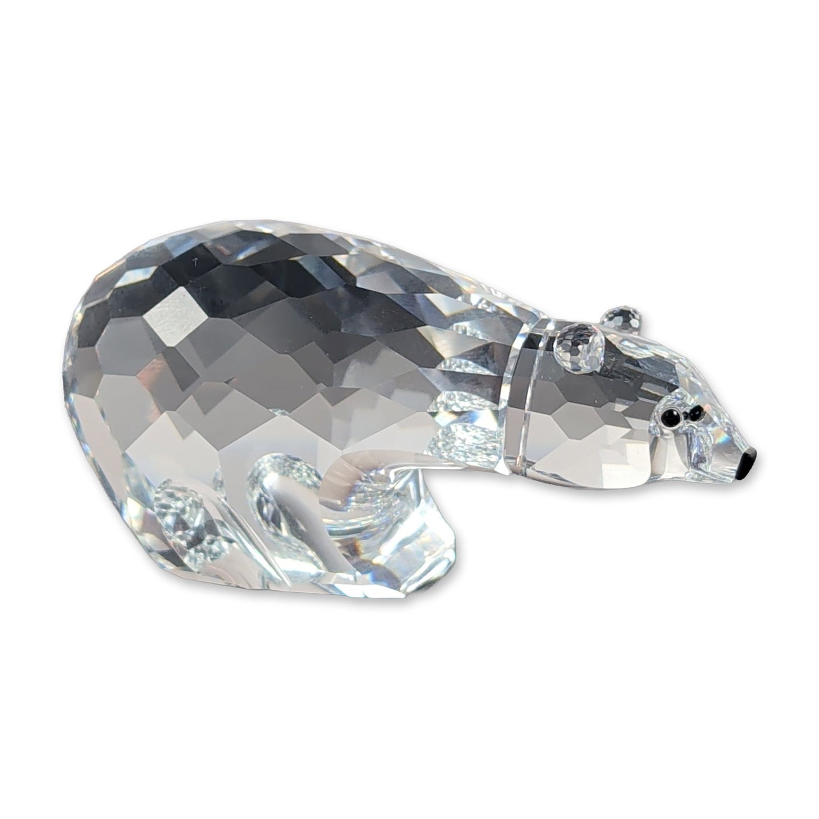 Swarovski Silver Crystal Polar Bear Figurine: Swarovski Silver Crystal polar bear figurine in faceted clear lead crystal, depicting a bear in an arched walking pose. The piece features a fully faceted body and head with inset black crystal eyes a