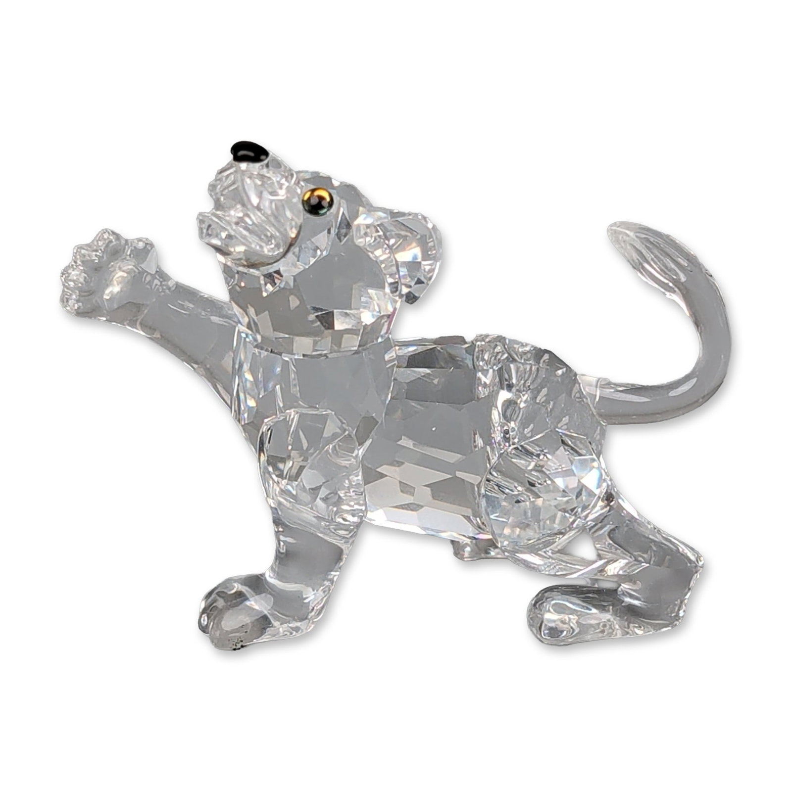 Swarovski Silver Crystal Figurine, Lion Cub: Swarovski Austrian faceted lead crystal figurine of a lion cub in a playful, paw raised pose. The clear multifaceted body is accented with a jet black crystal nose and amber-toned crystal eyes with bl