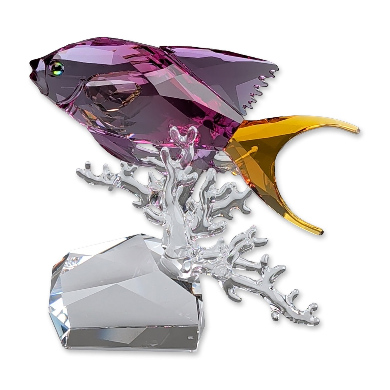 Swarovski Crystal Paradise Fish Figurine, Anthias: Anthias fish figurine in faceted fuchsia purple lead crystal with an amber yellow forked tail. The fish is mounted on clear crystal branching coral set upon a multi-faceted clear crystal plinth. The e