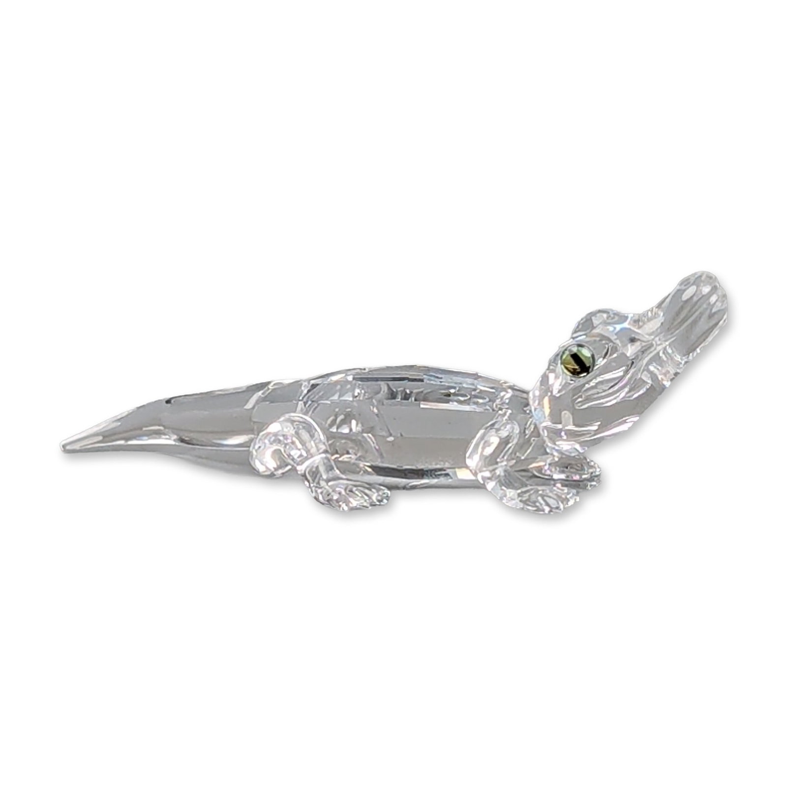 Swarovski Silver Crystal Figurine, Alligator: Swarovski Silver Crystal alligator figurine in faceted clear lead crystal, depicted in a crawling pose with a curved tail. The head features two inset dark crystal eyes with a greenish-gold metallic