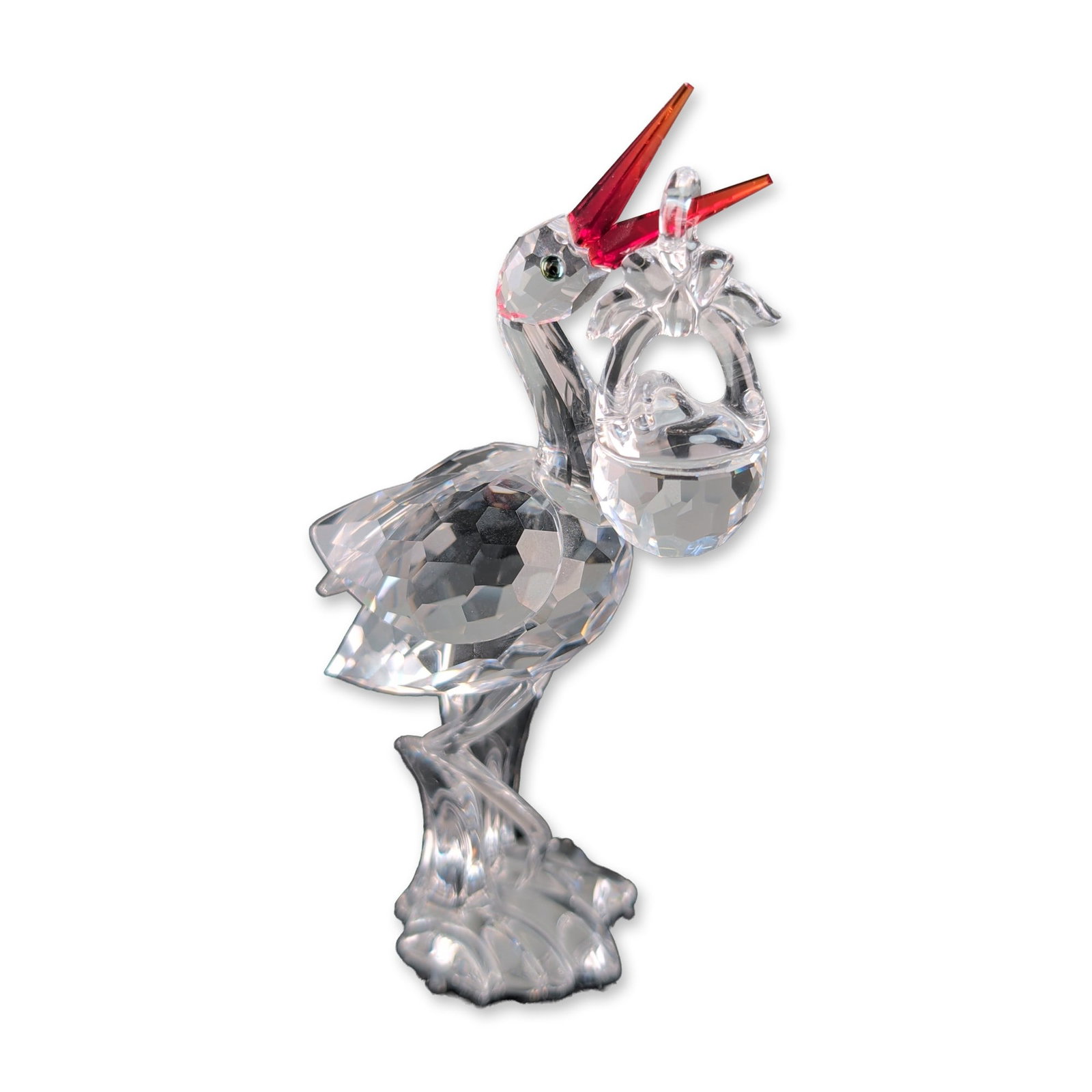Swarovski Crystal Stork With Baby Figurine: Swarovski crystal figurine, Stork with Baby, from the When We Were Young collection. The multi-faceted clear lead crystal bird is modeled in a standing position with its head turned, holding a faceted