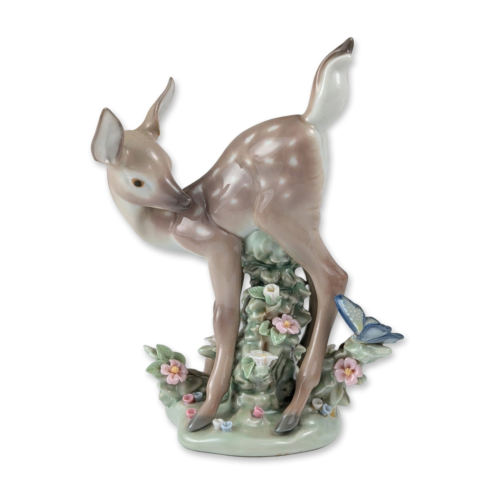 Lladro Glazed Porcelain Hi There! Fawn Figurine1005672: Lladro glazed porcelain figurine titled Hi There!, model number 1005672, depicting a young spotted fawn standing beside a flowering bush with a blue butterfly. The piece is finished in a palette of mu