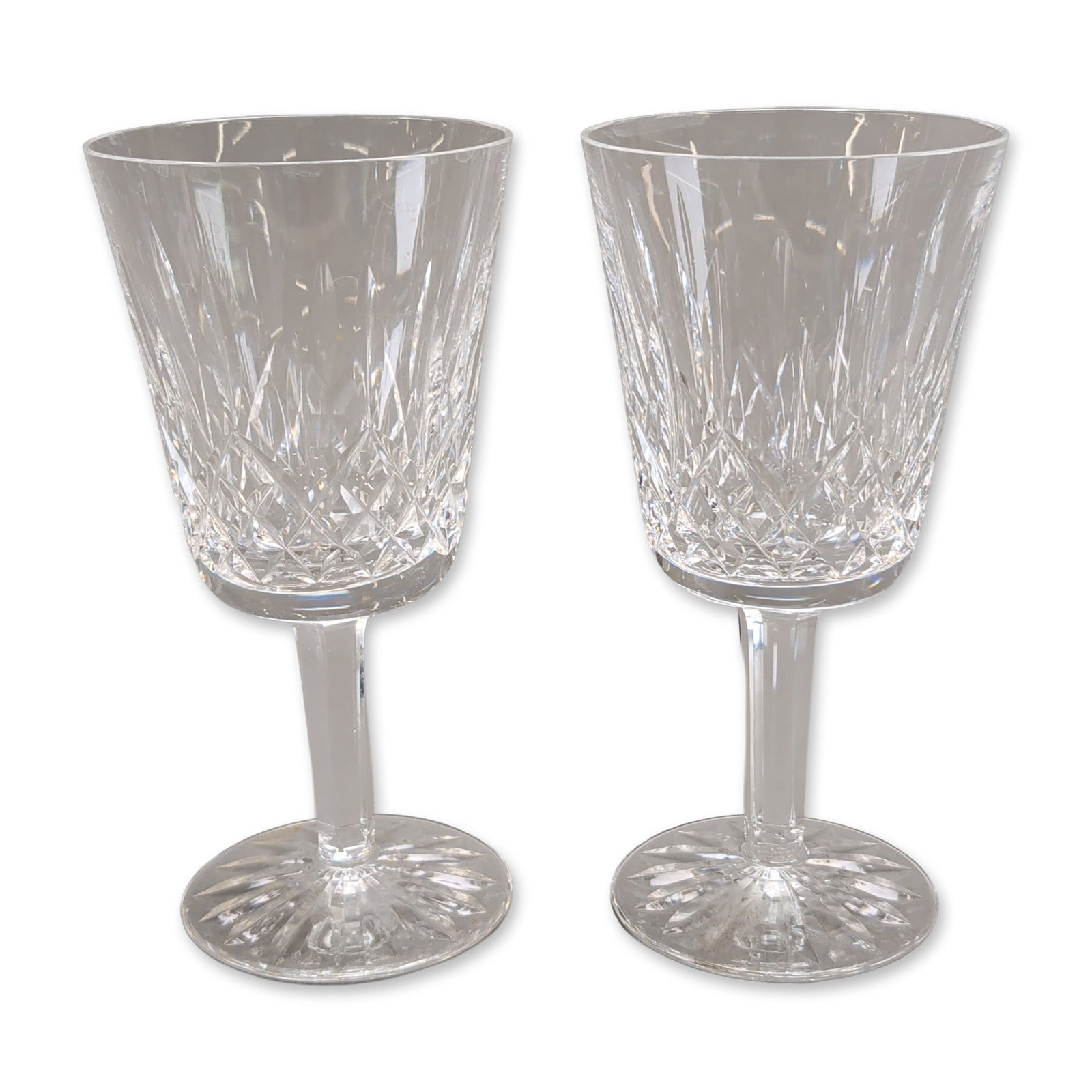 Pair of Waterford Lismore Crystal Goblets: Waterford crystal goblets in the Lismore pattern. Hand-cut lead crystal featuring a band of diamond crisscross cuts to the lower bowl with elongated vertical wedge cuts extending toward the rim. The f