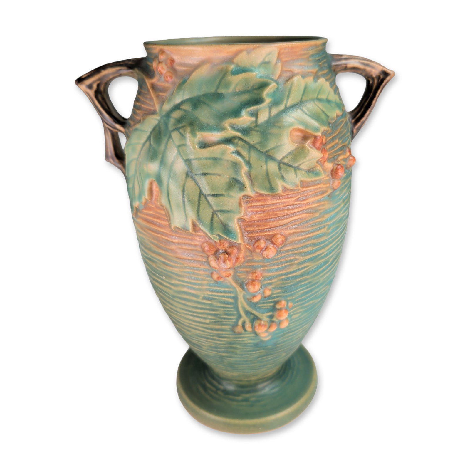 Roseville Bushberry Two-Handled Green Pottery Vase: Roseville Pottery earthenware vase in the Bushberry pattern, featuring a two-handled footed form. The body is decorated with relief-molded serrated green leaves and orange berry clusters set against a