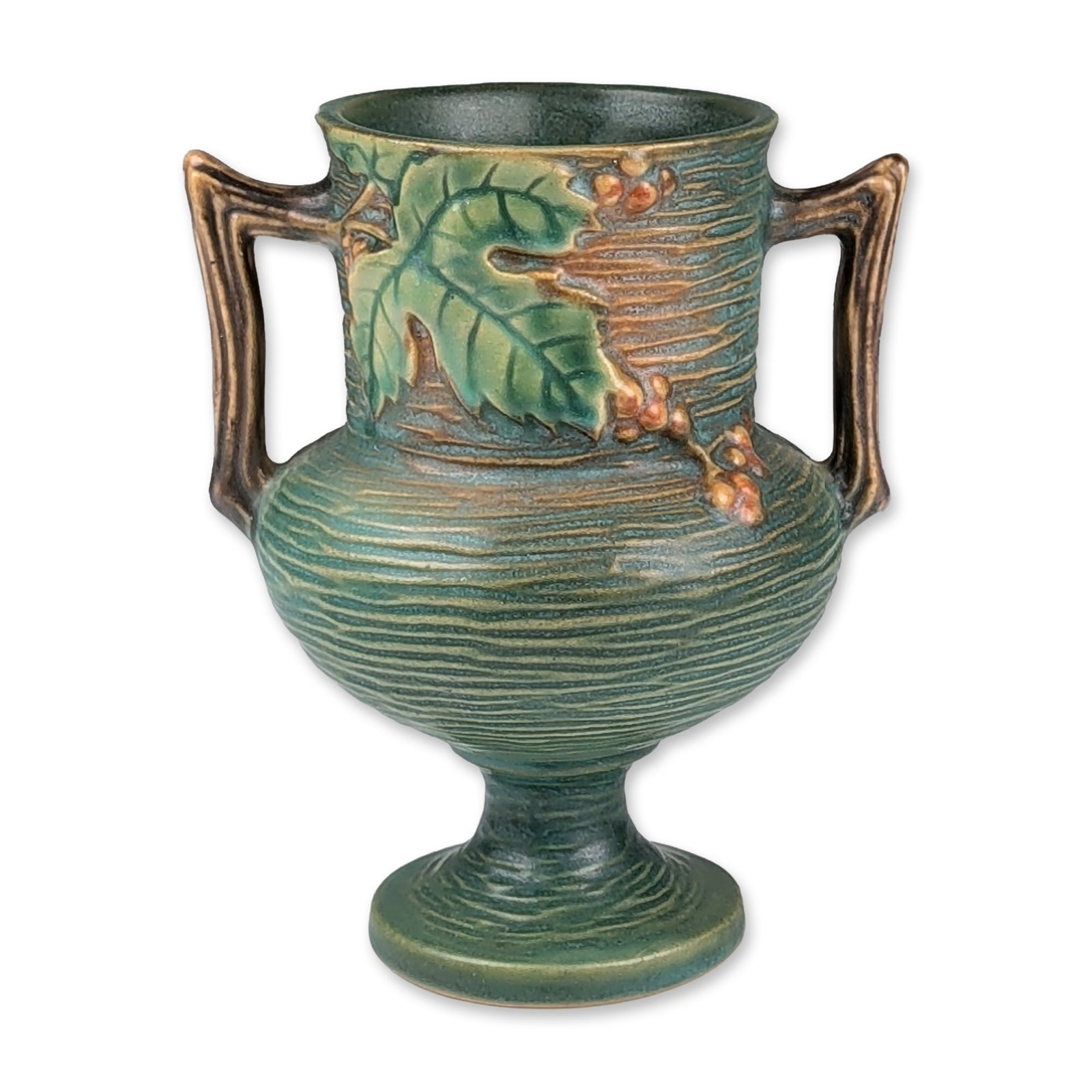Roseville Pottery Pedestal Vase, Bushberry Green: Roseville Pottery. Bushberry pattern double-handled vase in a matte green glaze. The vessel features a bulbous body with horizontal ribbing, relief-molded serrated green leaves, and clusters of orange