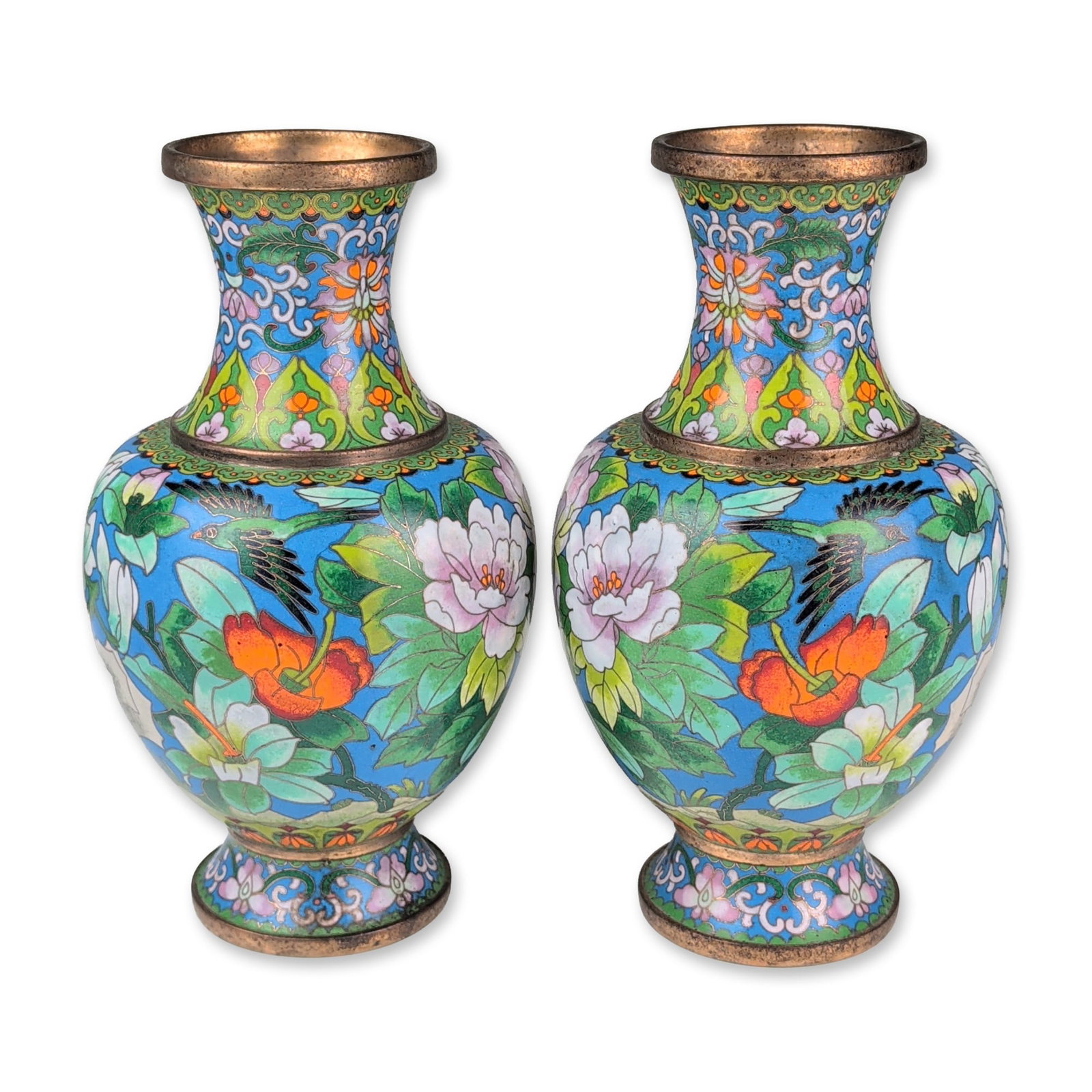Pair of Chinese Cloisonne Enamel Bird and Flower Vases: Chinese, mid-20th century. A pair of matching cloisonne enamel vases on metal, featuring a birds and flowers motif set against a cobalt blue ground. The decoration includes white magnolia blossoms, or
