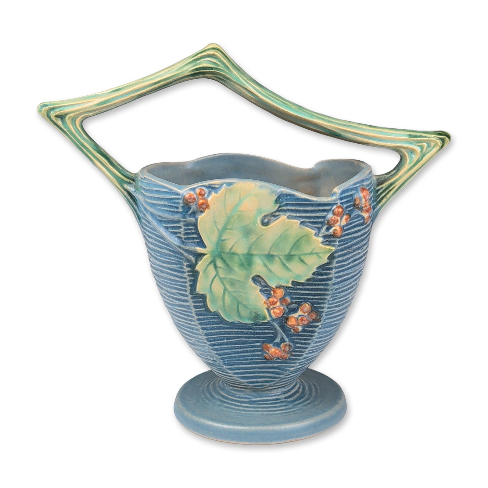 Roseville Pottery Vase, Blue Bushberry: Roseville Pottery handled basket in the Bushberry pattern, Zanesville, Ohio, circa 1941. The earthenware piece features a flared, horizontally-ribbed body with a matte blue glaze, decorated with relie