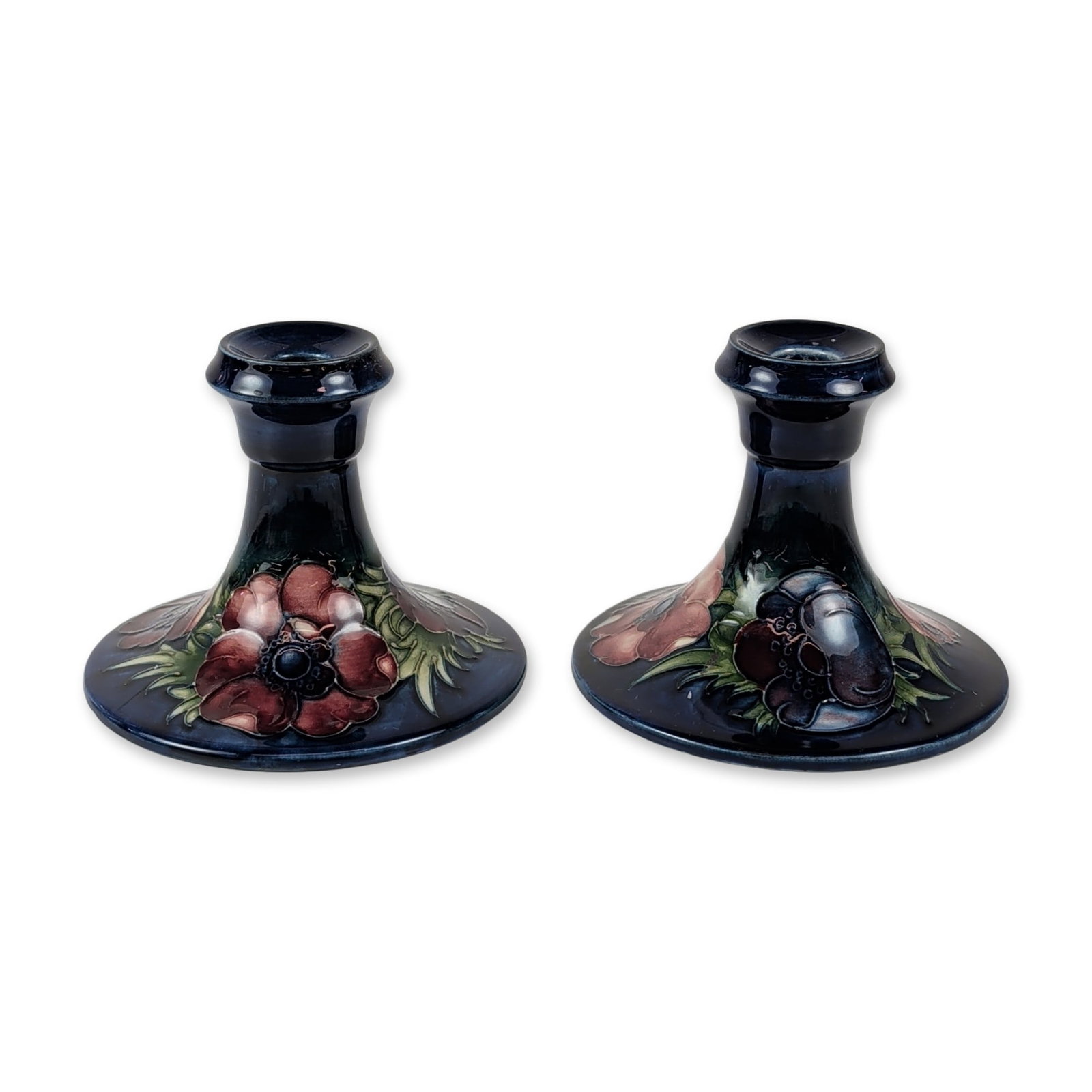 Pair of Moorcroft Anemone Pattern Ceramic Candlesticks: Handcrafted in Staffordshire, England, this matching pair of earthenware candlesticks showcases the iconic Anemone pattern, a creation of renowned master potter Walter Moorcroft. Each candlestick is a