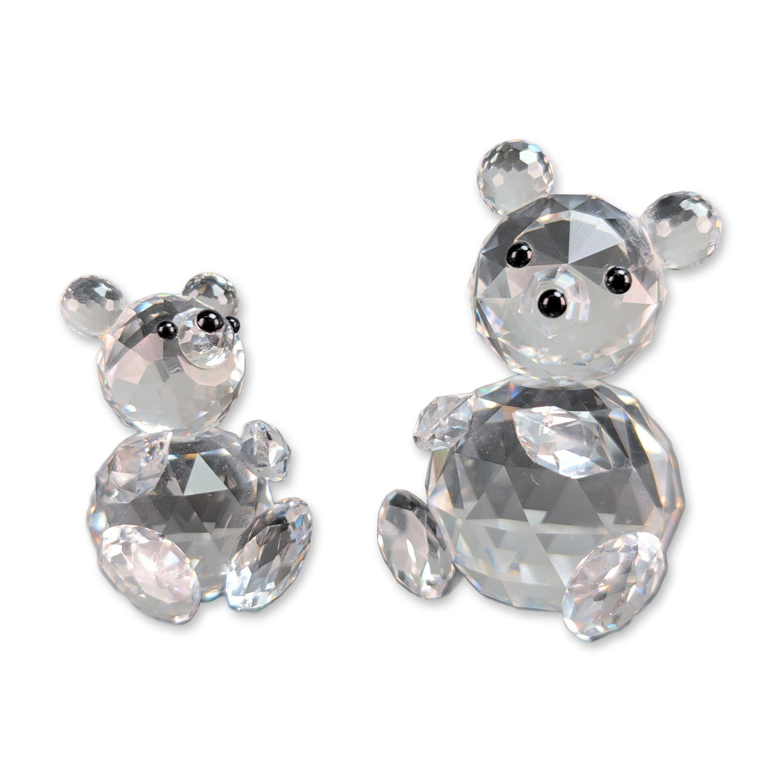 2pc Swarovski Crystal Sitting Teddy Bear Figurines: Swarovski faceted clear lead crystal Sitting Bear figurines, featuring black crystal bead eyes and noses. The bases are etched with a swan logo encircled by the text SWAROVSKI in uppercase letters. Th