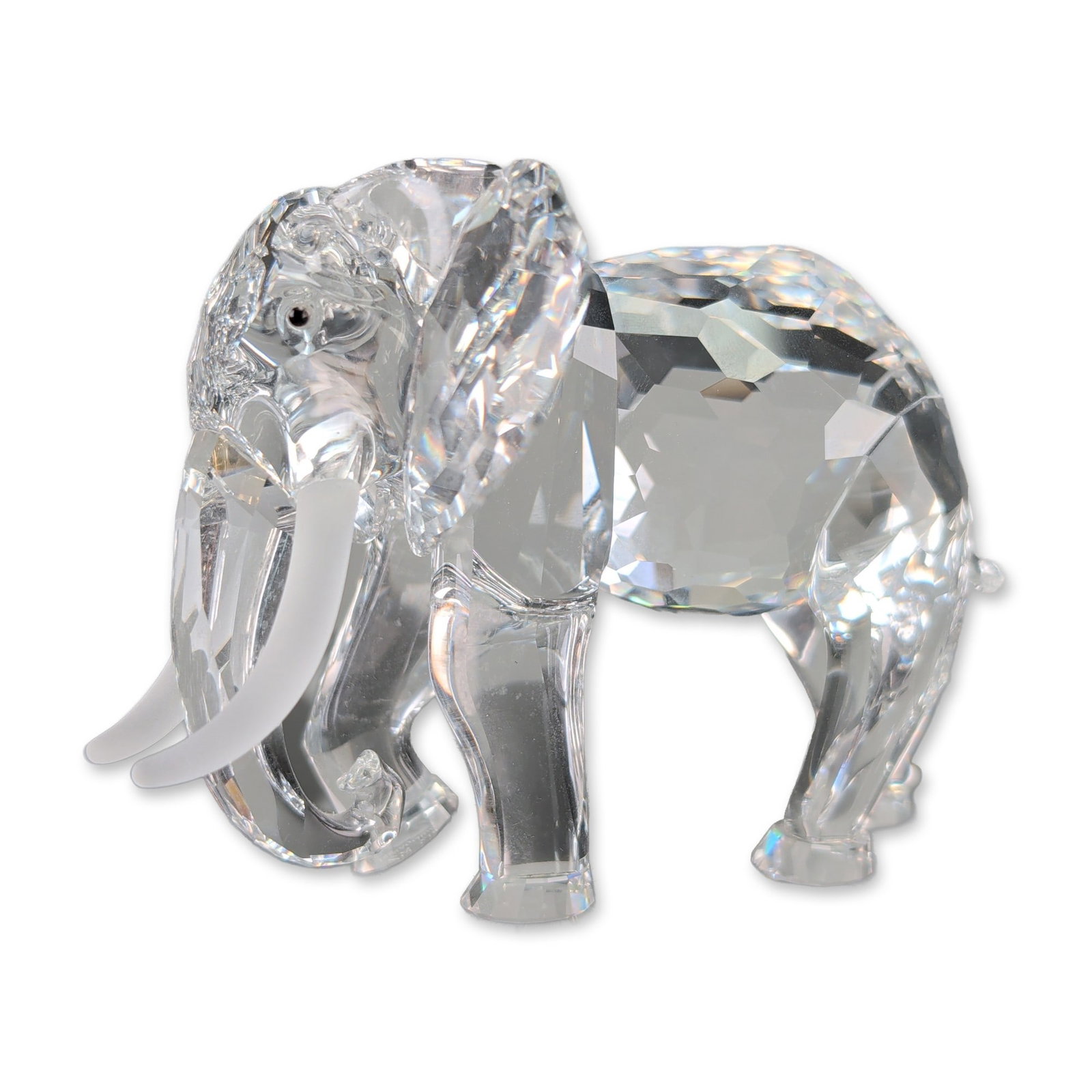 Swarovski 1993 SCS Crystal African Elephant Figurine: Swarovski 1993 SCS annual edition Inspiration Africa series depicting a faceted lead crystal elephant figurine with frosted tusks. The piece features a multi-faceted body, head, and legs with an uprig
