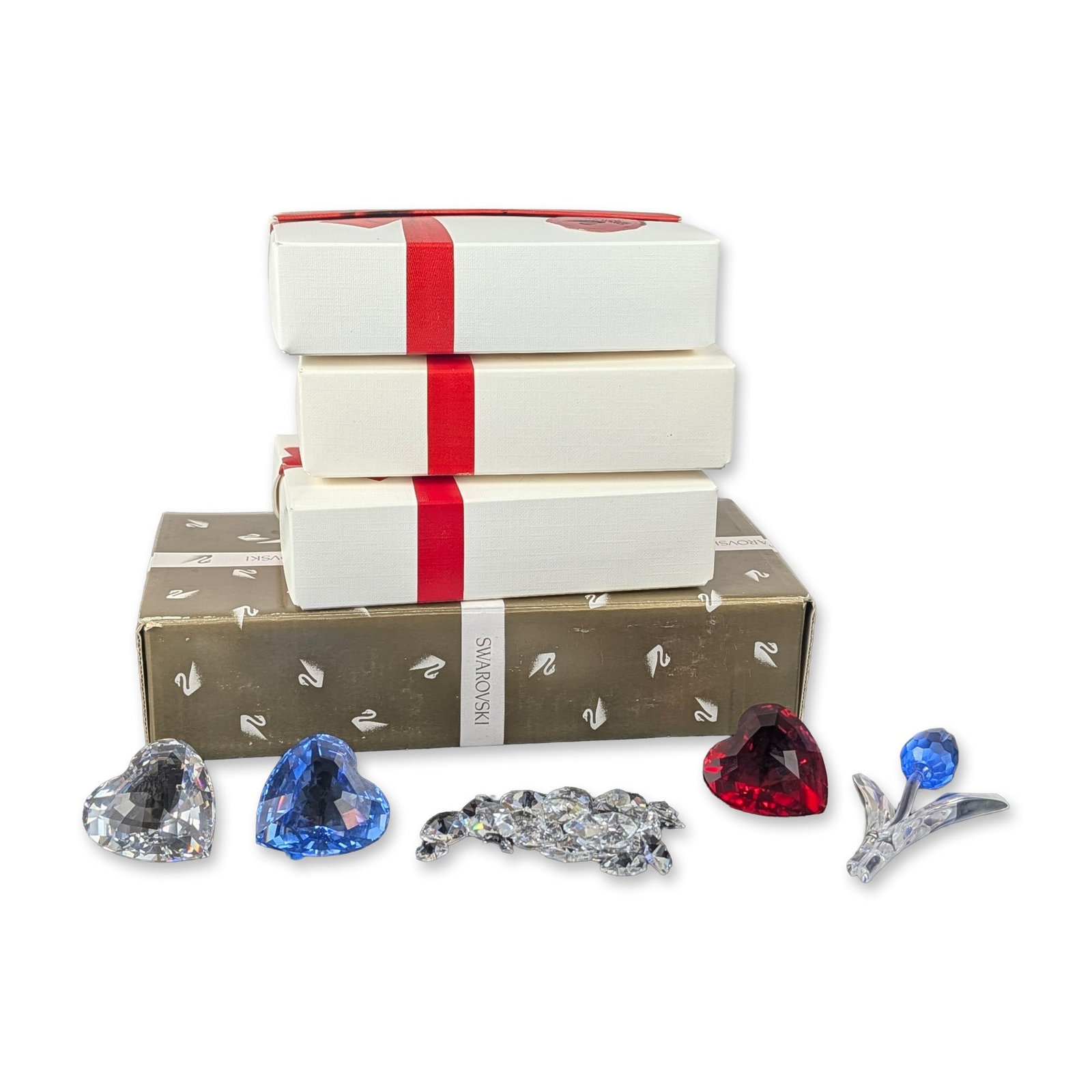 5pc Swarovski Crystal Hearts and Tulip Figurine Collection: Swarovski. Four decorative items in faceted lead crystal, featuring three heart-shaped forms, a bag of mini crystal hearts, and one floral figurine. The collection includes one heart in sapphire-tone 