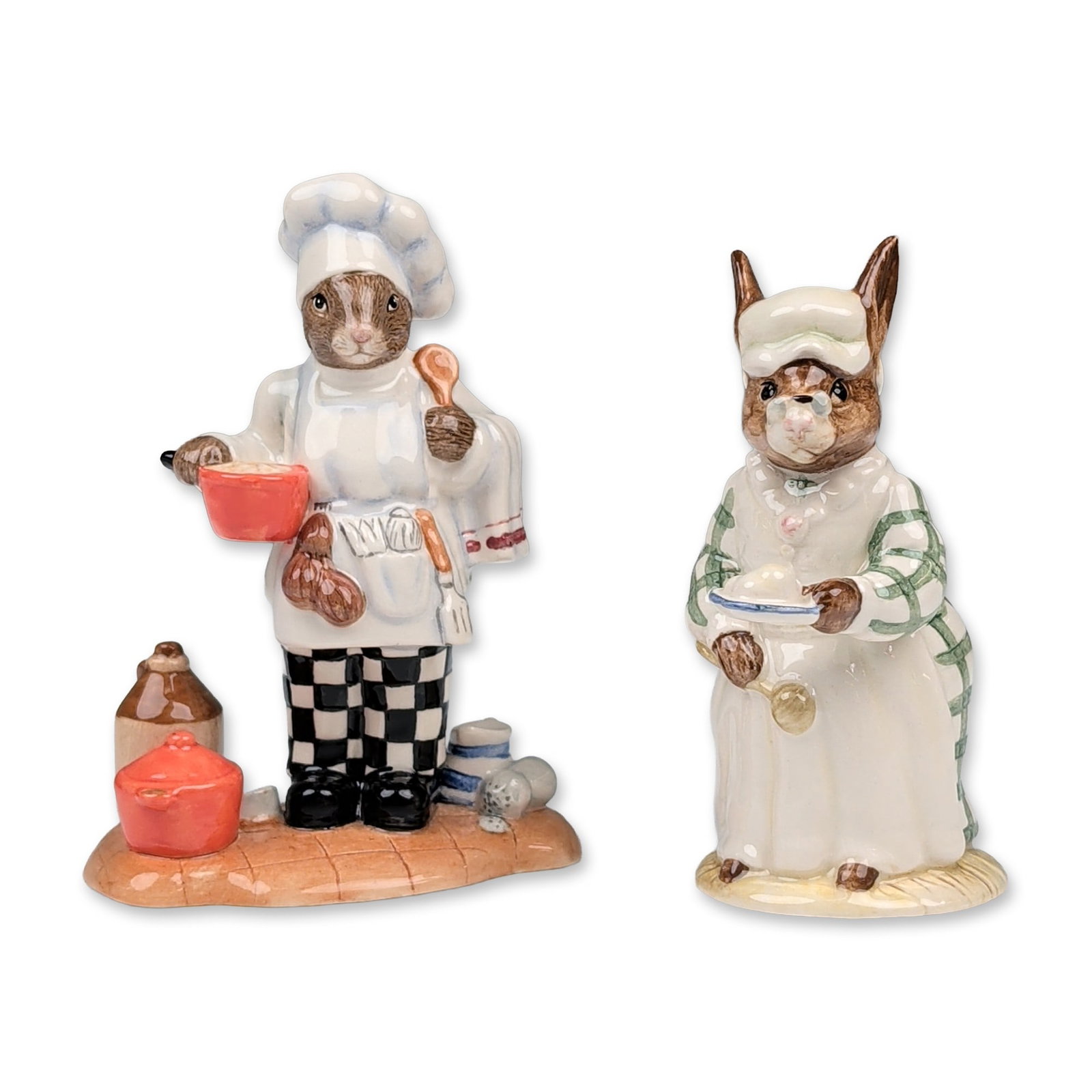 2pc Royal Doulton Bunnykins Cook and Chef Figurines: Royal Doulton. A pair of glazed ceramic figurines from the Bunnykins series. The lot includes Cook Bunnykins (DB 85), modeled as a rabbit in a green checkered dress and mob cap holding a mixing bowl, 