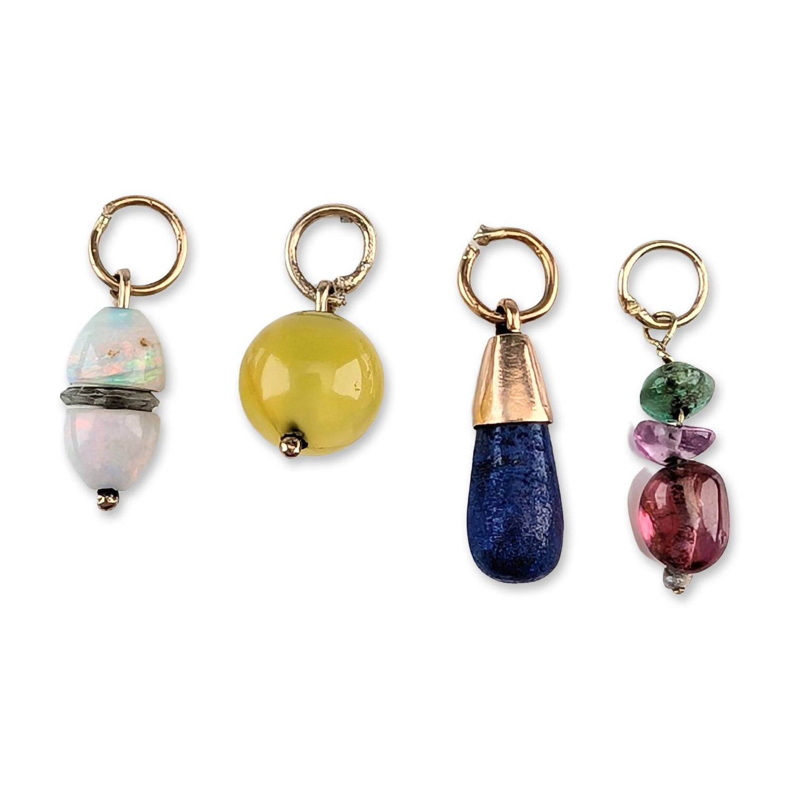Group of Four Gemstone and 8K, 10K, and 12K Gold Charms: An assortment of four gemstone charms in various configurations, each suspended from a yellow gold split ring. The collection features a double-beaded opal charm displaying play-of-color with a transp