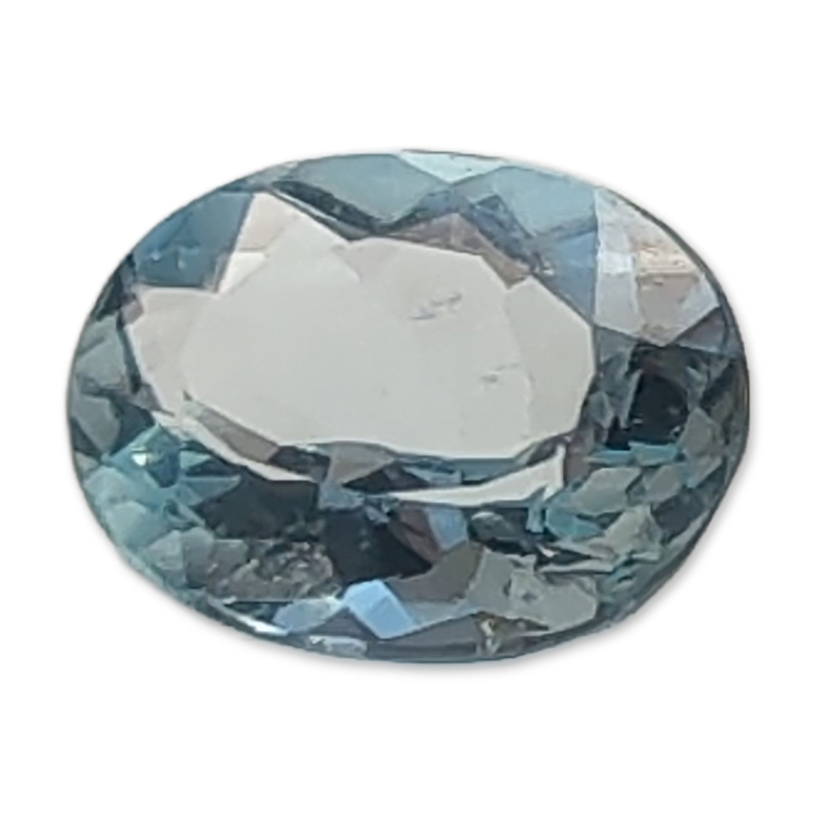 Oval Faceted Aquamarine Loose Gemstone: Oval faceted aquamarine loose gemstone, featuring a transparent pale icy blue color. The stone is cut with a slightly shallow pavilion, resulting in a visible window in the center. Internal clarity