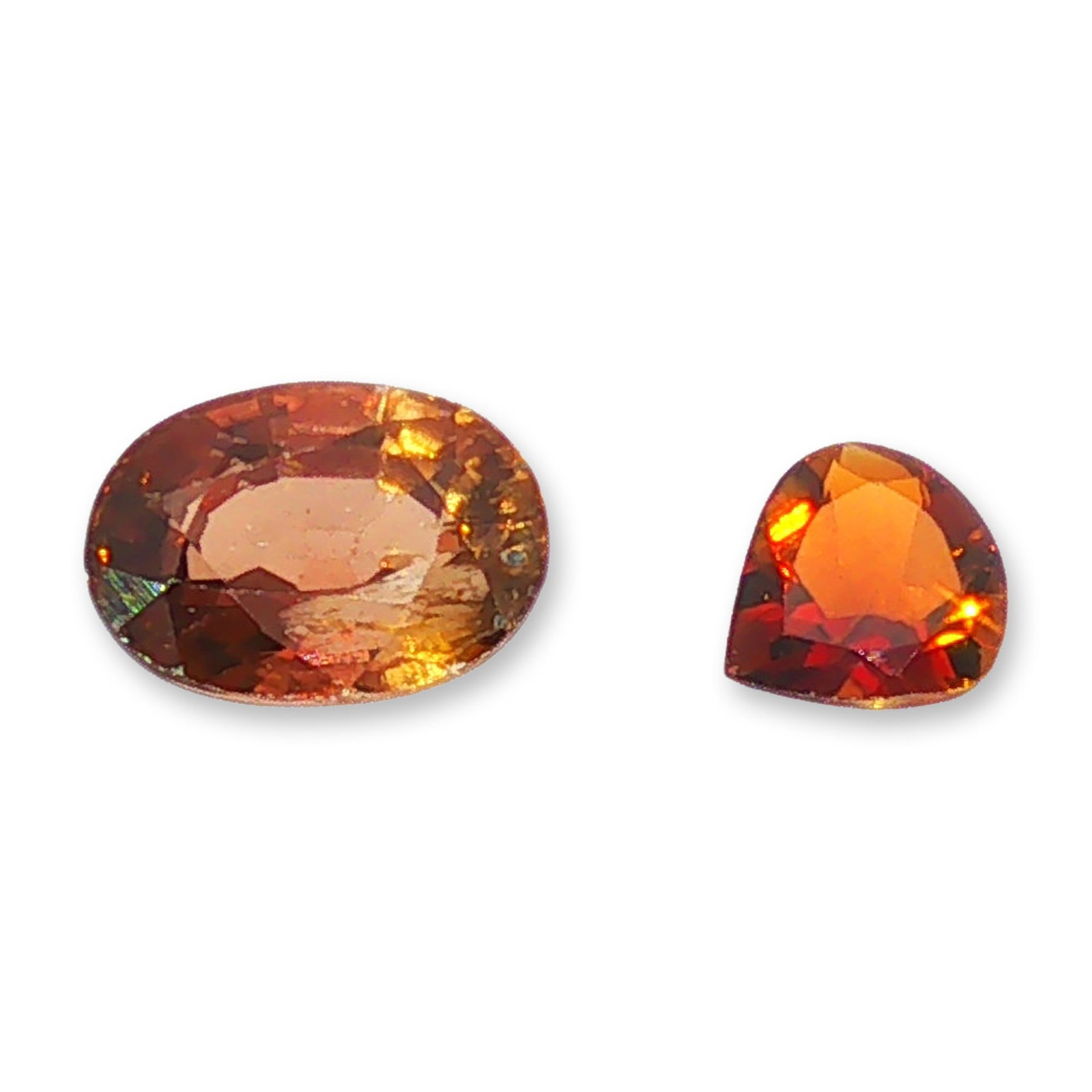 2pc Loose Oval and Pear Cut Brown-Orange Gemstones: Pair of loose faceted gemstones. The larger stone is an oval-cut gemstone featuring a brownish-orange color with internal treacle-like flow lines. The smaller stone is a modified pear or shield-shaped