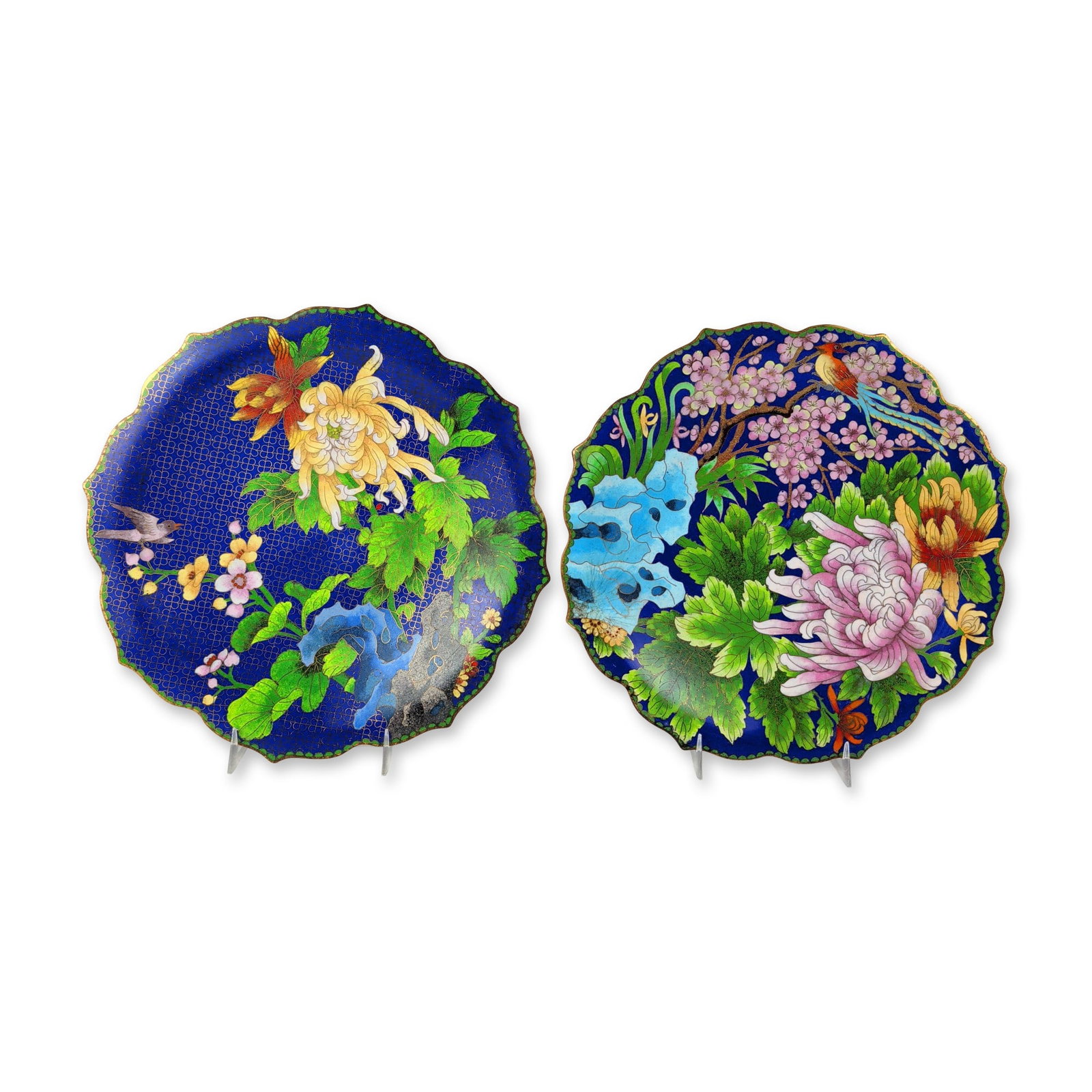 2pc Chinese Cloisonne Enamel Lobed Plates: Pair of Chinese decorative lobed chargers in polychrome enamel on a metal base, featuring scalloped rims with gilded edges. The first plate depicts a pink chrysanthemum and yellow blossoms with a long