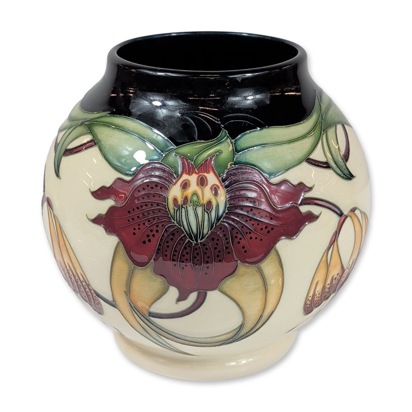 Moorcroft Anna Lily Pattern Earthenware Bulbous Vase: Moorcroft Pottery, England. Bulbous vase in glazed earthenware, featuring the Anna Lily pattern designed by Nicola Slaney. Decoration consists of tubelined lily blossoms and foliate motifs in shades o