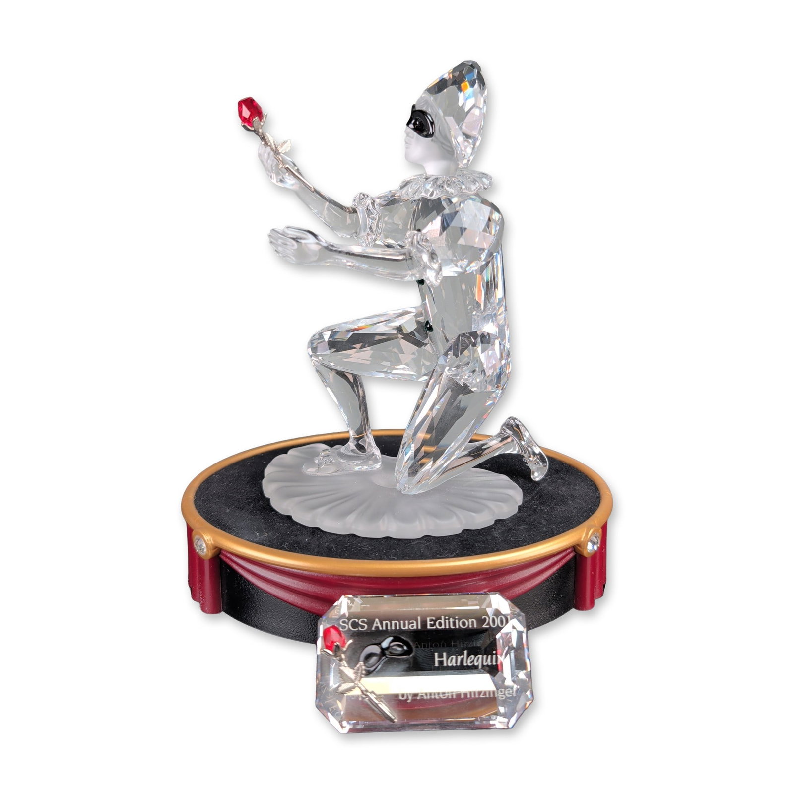 3pc Swarovski SCS 2001 Harlequin Crystal Figurine w/ Stand & Title Plaque: Swarovski Crystal Society Annual Edition 2001 Harlequin crystal figurine, the final piece in the Masquerade trilogy. Designed by Anton Hirzinger, the faceted lead crystal figure is depicted in a kneel