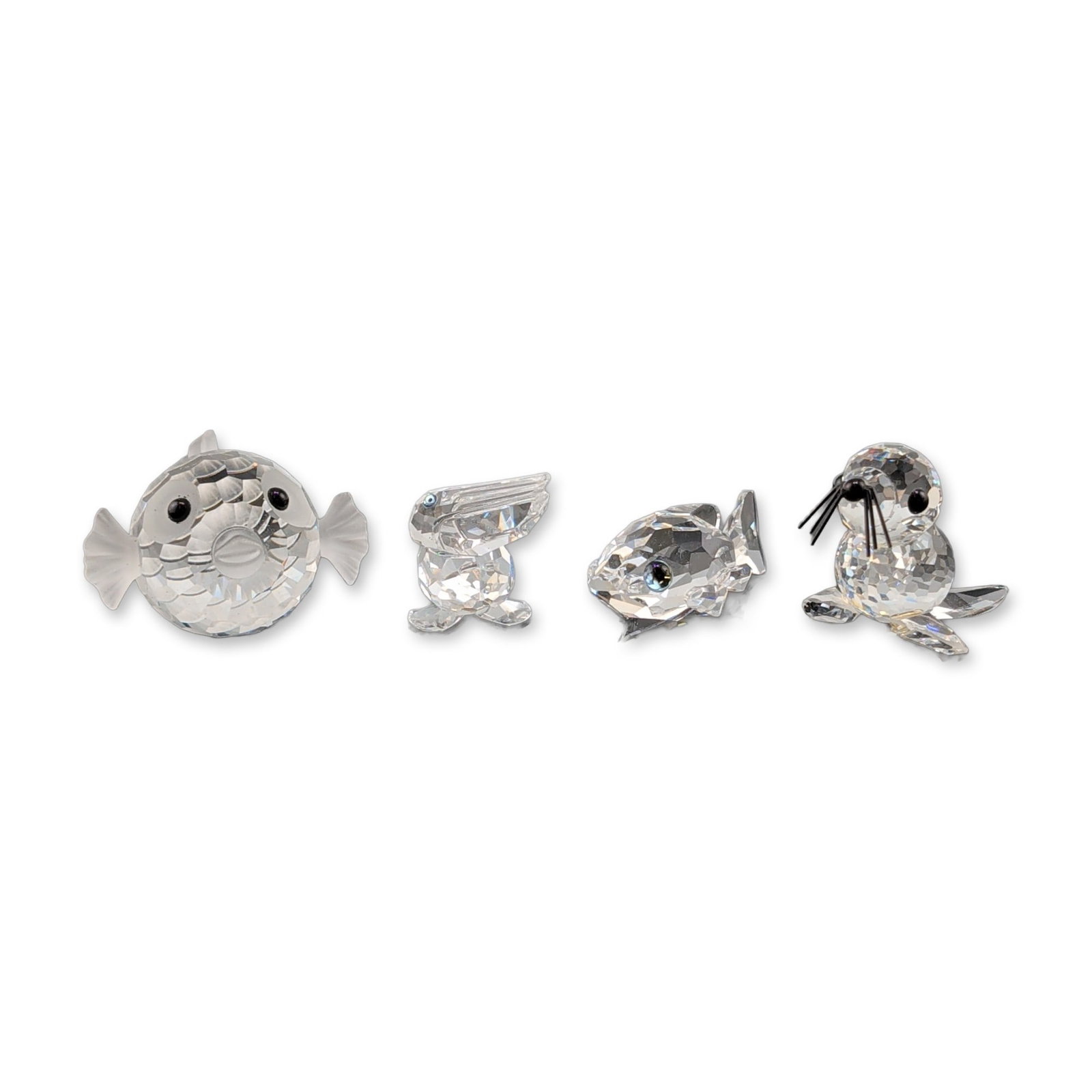 4pc Swarovski Silver Crystal Animal Figurines: Four-piece collection of miniature animal figurines from the Silver Crystal line, crafted in faceted lead crystal with frosted and black crystal accents. The group includes a seal with whiskers, a pel