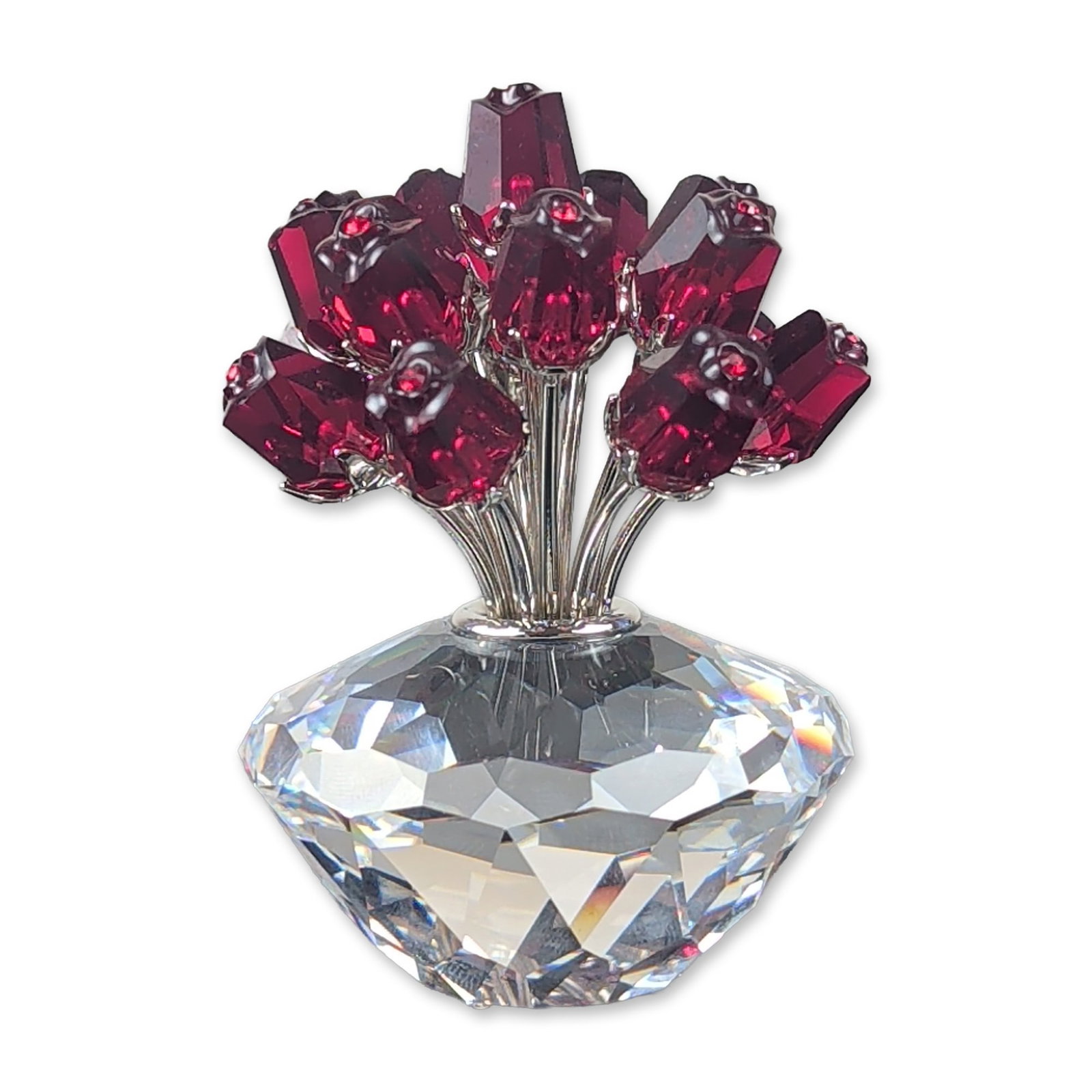 Swarovski Crystal Vase of Roses Figurine: Swarovski crystal figurine, Vase of Roses, featuring fifteen red faceted crystal blossoms mounted on silver-tone metal stems and set within a clear brilliant-cut faceted crystal vase. A laser-etched s