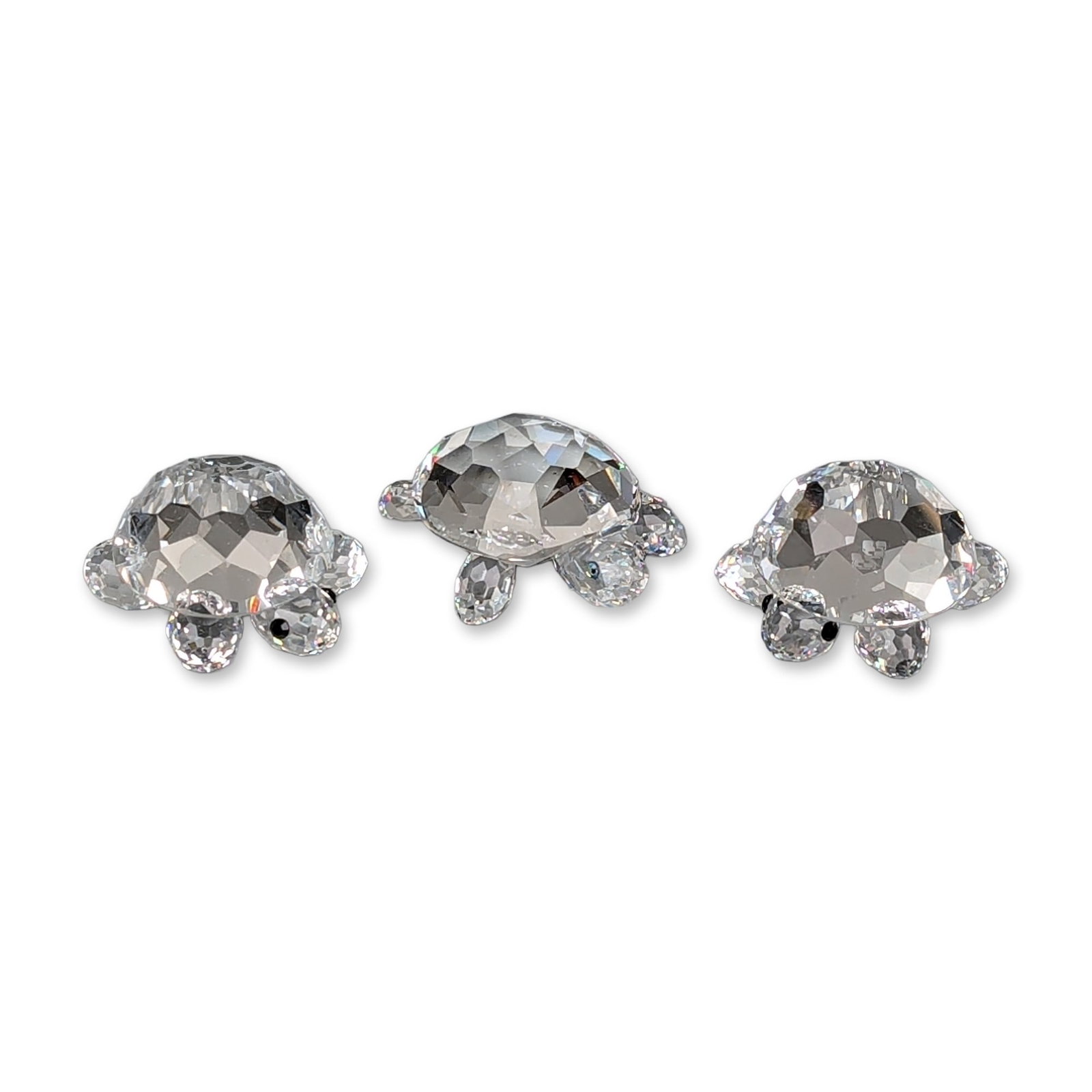 Three Swarovski Silver Crystal Figurines, Turtles: Swarovski trio of faceted clear lead crystal turtle figurines from the Silver Crystal collection. Each figure features a faceted shell, four flippers, a head with two applied black bead eyes, and a sm