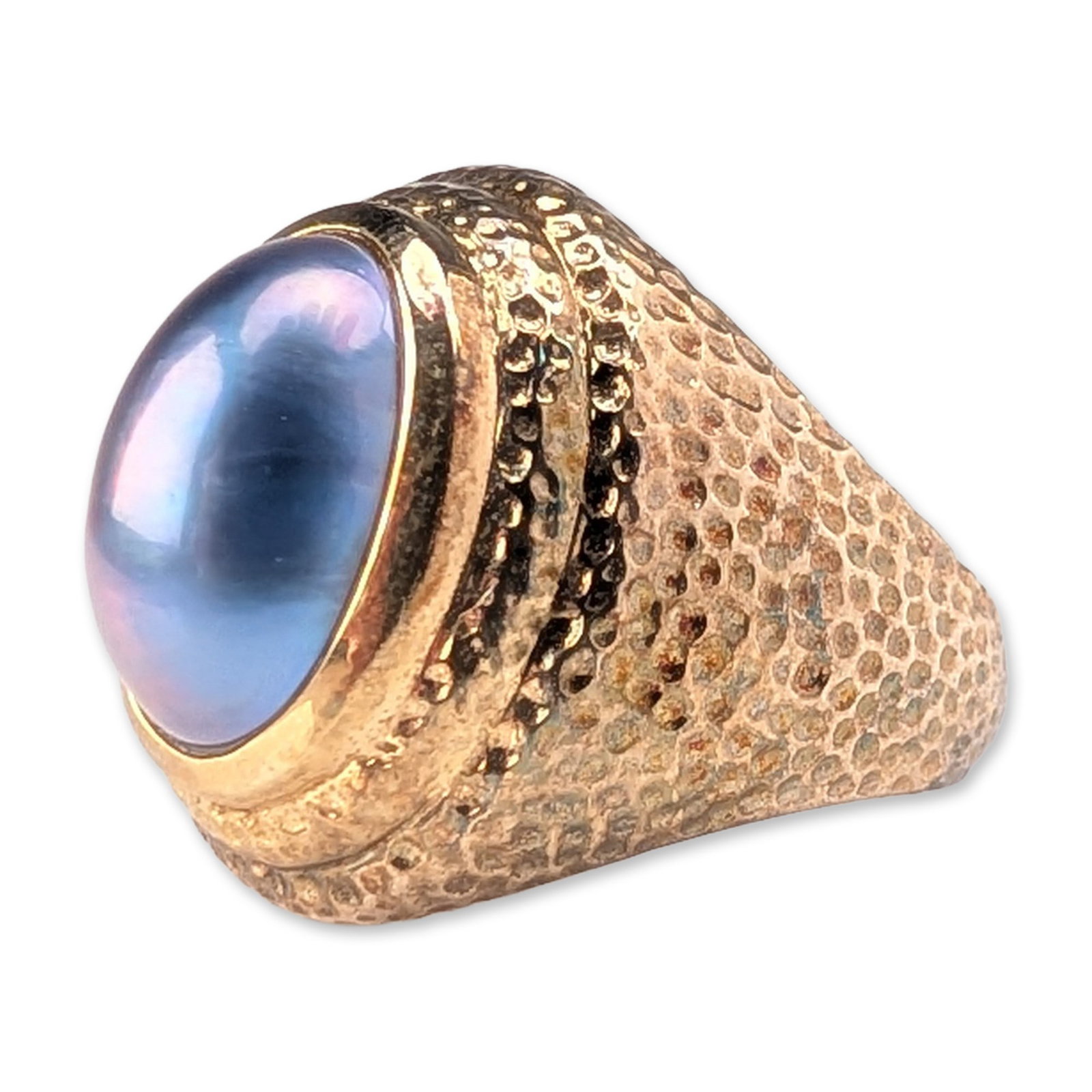 Gold-Plated Hammered Mabe Pearl Signet Ring: Silver signet-style statement ring with gold plating. The ring features a large bezel-set oval cabochon mabe pearl, translucent light blue in color with pink and purple chatoyant effects. The domed fa