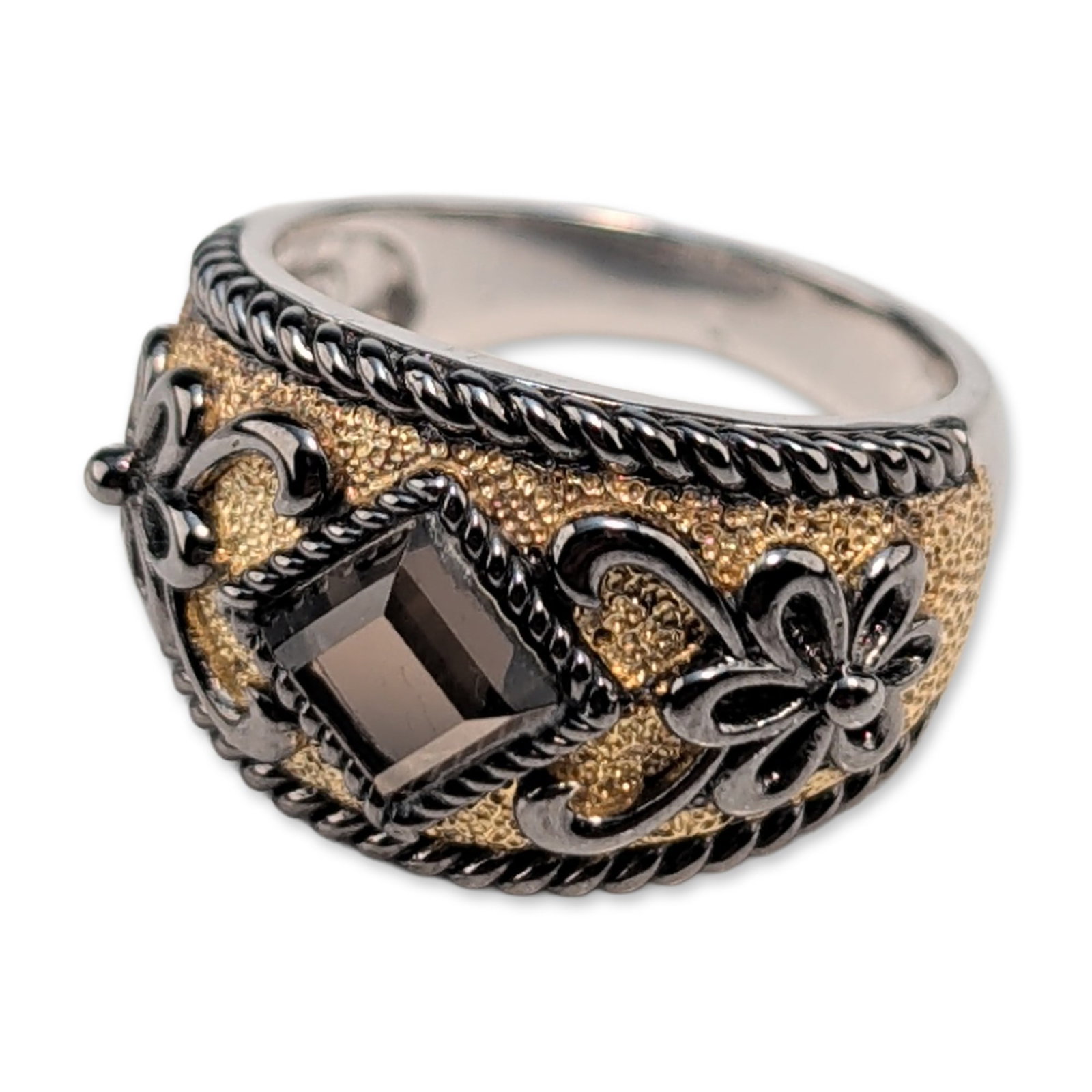 Sterling Silver and Smoky Quartz Gemstone Ring: A sterling silver cocktail ring featuring a wide domed head with decorative elements. The centerpiece is a square-cut faceted smoky quartz bezel-set within an ornate frame of blackened scrollwork and 