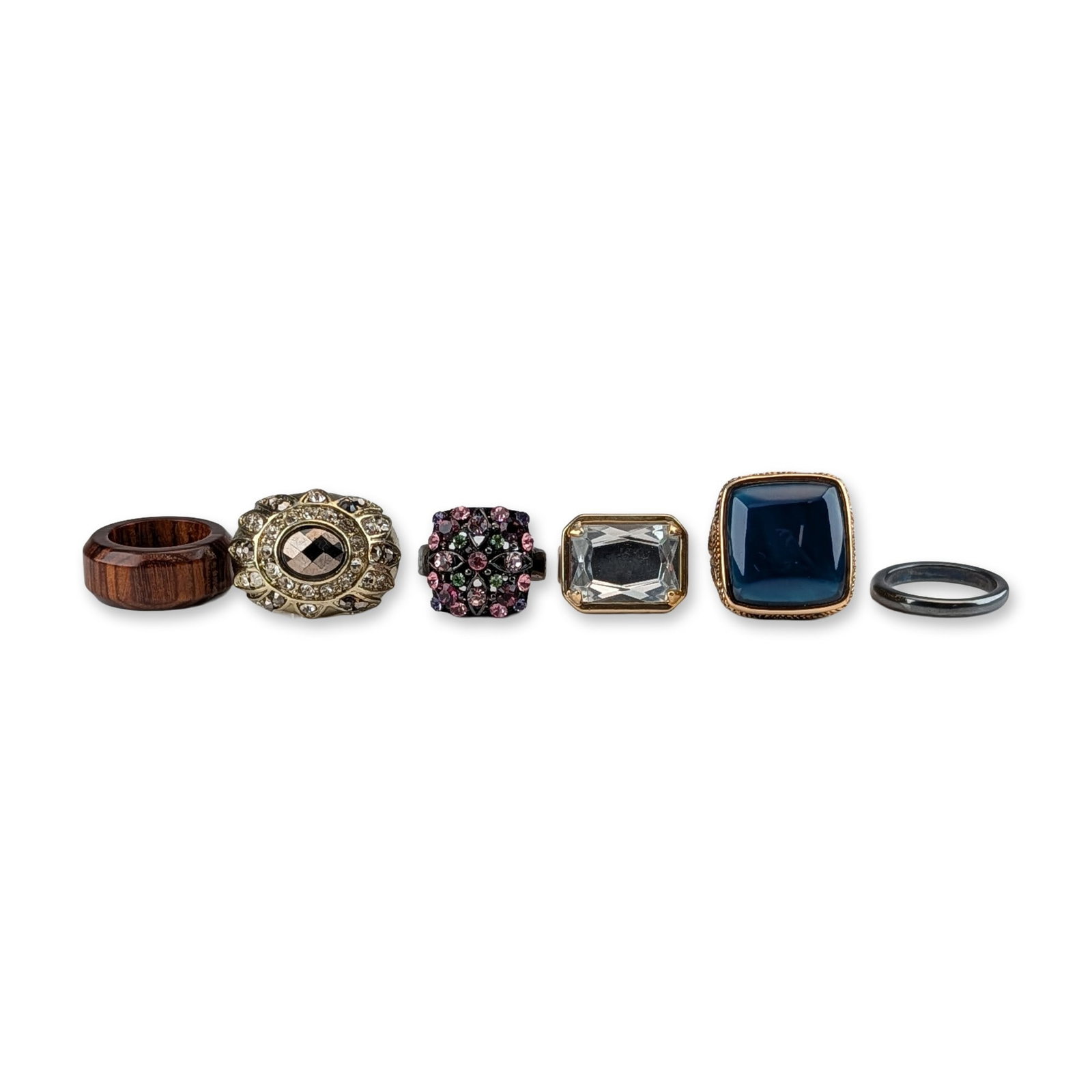 6pc Fashion and Cocktail Rings: Contemporary and vintage style. Group of six fashion and cocktail rings in various materials including polished wood, gold-tone metal, and blackened metal. The collection features a wide natural wood 