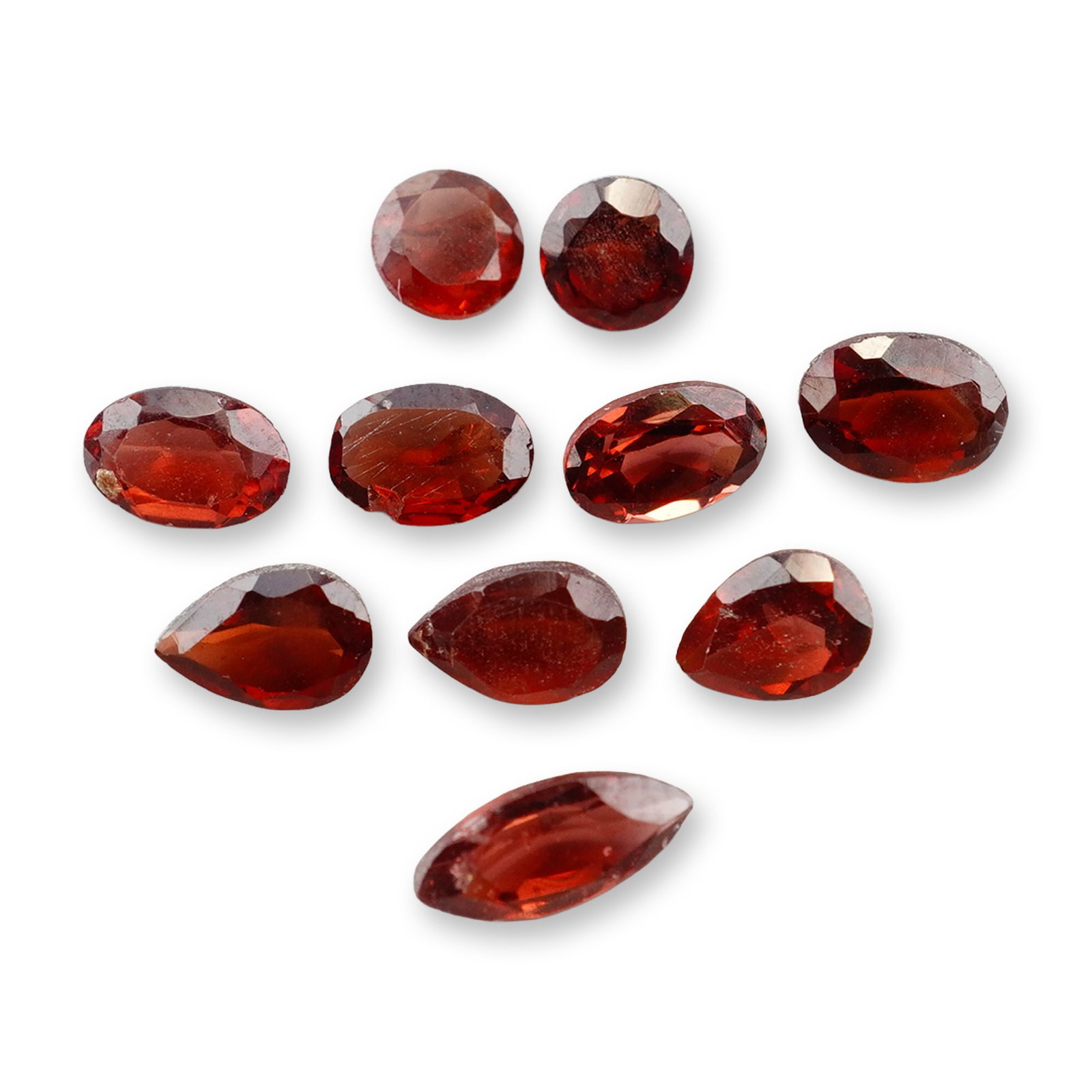 10pc Red Garnet Gemstones in Vatious Shapes and Sizes: Grouping of 10 garnet gemstones. The spiritual meaning of a garnet centers on vitality, protection, and devotion. Known as a stone of passion and commitment, it is highly valued for grounding scattere