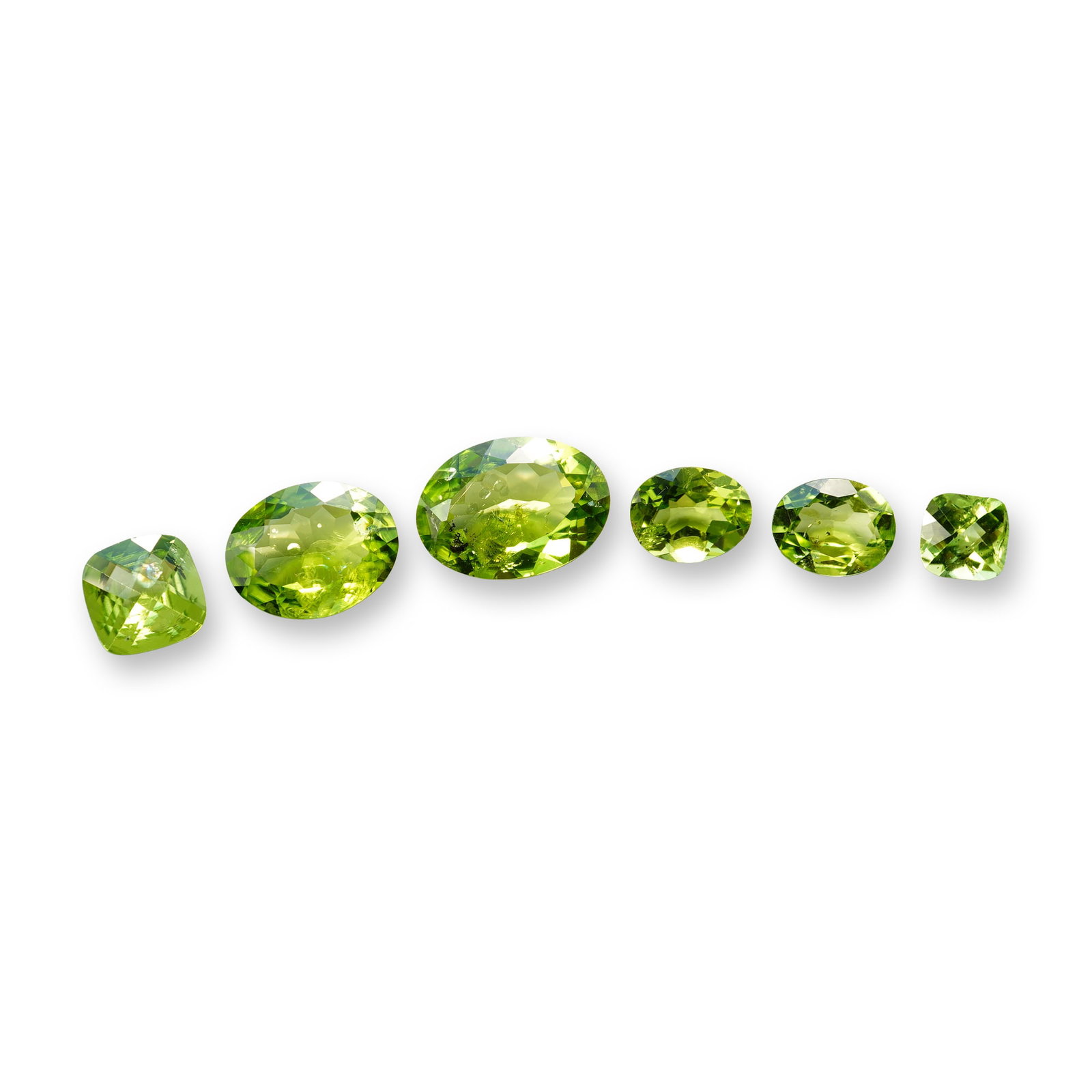 Collection of Faceted Peridot Gemstones: An assortment of loose peridot gemstones, featuring a saturated yellowish-green to olive hue. The collection consists of four oval mixed-cut stones and two cushion mixed-cut stones of varying sizes.